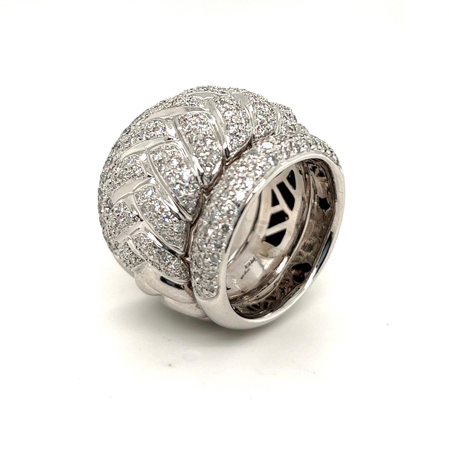 Attractive 18 karat white gold and diamond cocktail ring.

Entirely crafted in 18 karat white gold and designed as a bold wide band ring featuring a braided pattern. The front side of the ring is pavé-set with numerous brilliant-cut diamonds