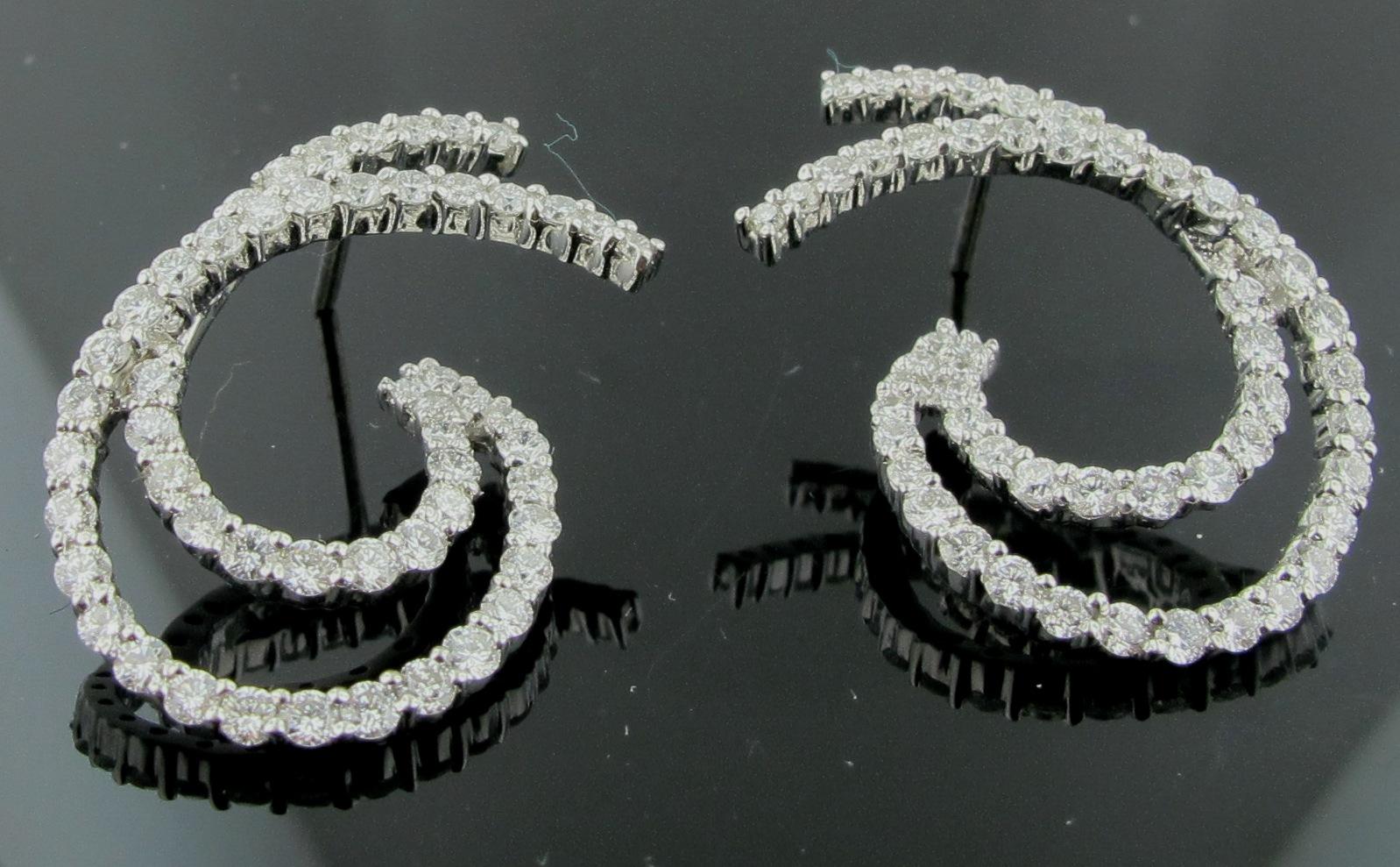 Set in 18 karat white gold are 104 round brilliant diamonds, with a total weight of 2.25 carats.
These earrings are an alternative to diamond hoops. Double swirl design. 
