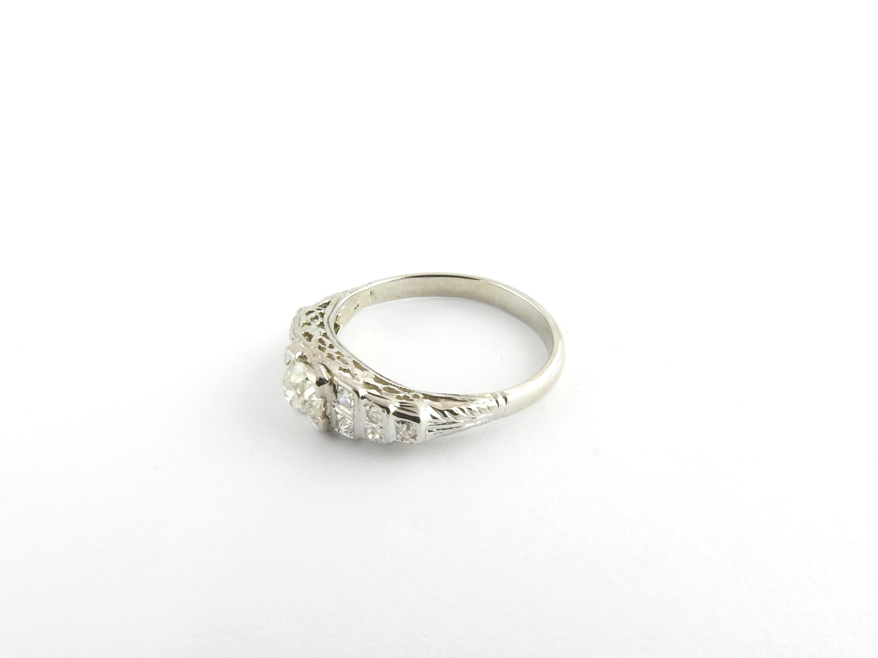 Vintage 18 Karat White Gold Diamond Engagement Ring Size 6.5

This sparkling ring features one round old mine cut diamond (.30 ct.) accented with 10 round single cut diamonds* set in beautifully detailed 18K white gold. Shank: 2 mm.
*Some chips