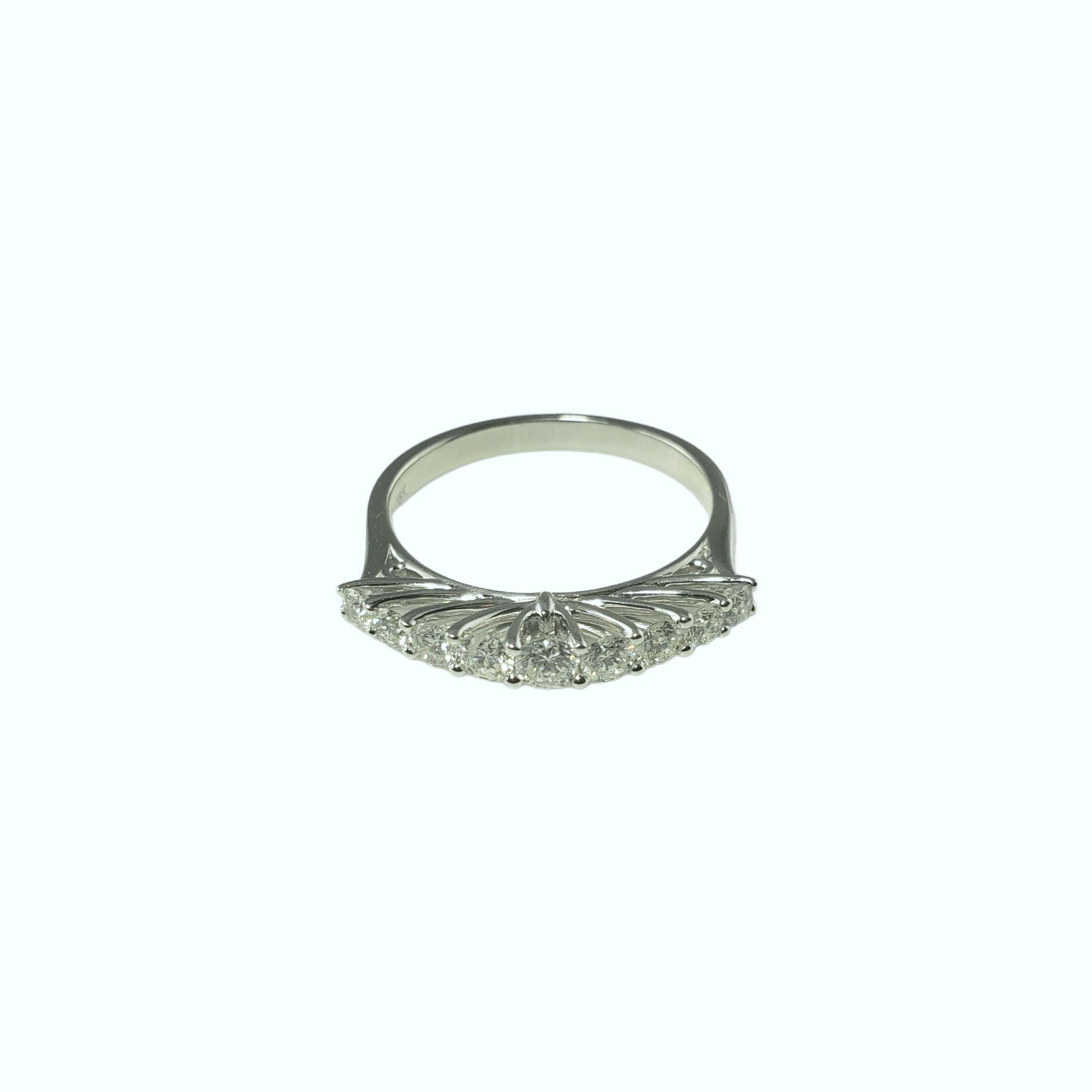 This sparkling ring features nine round brilliant cut diamonds* set in classic 18K white gold.  Width: 3 mm.  Shank: 2 mm.

*Slight chip to middle stone noted not visible to naked eye.

Approximate diamond weight: .54 ct.

Diamond color: