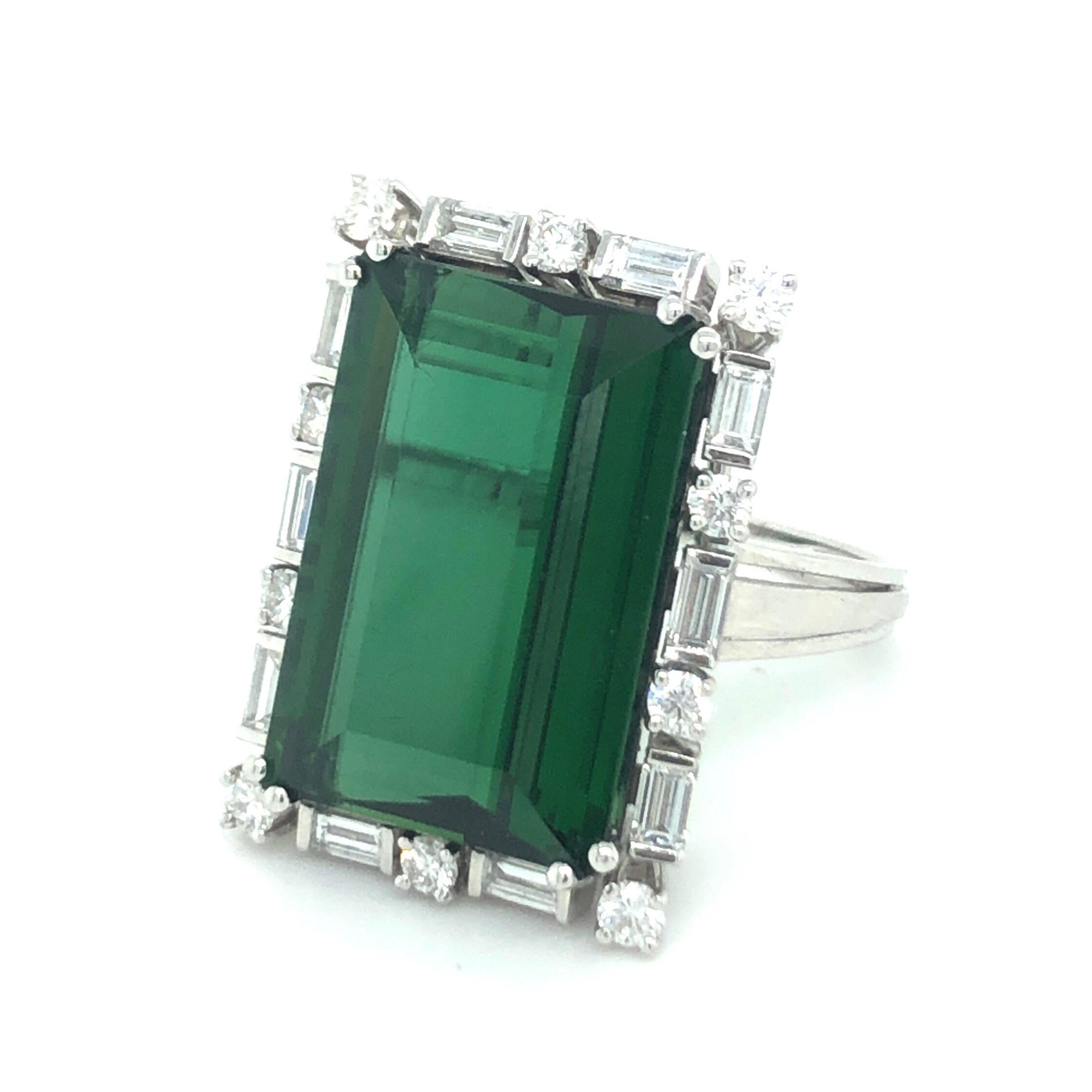 18 karat white gold and green tourmaline diamond dress/cocktail ring.
Spectacular cocktail ring set with a rectangular green tourmaline of circa 14.7 carats surrounded by a regularly arranged entourage of 10 brilliant-cut diamonds and 10