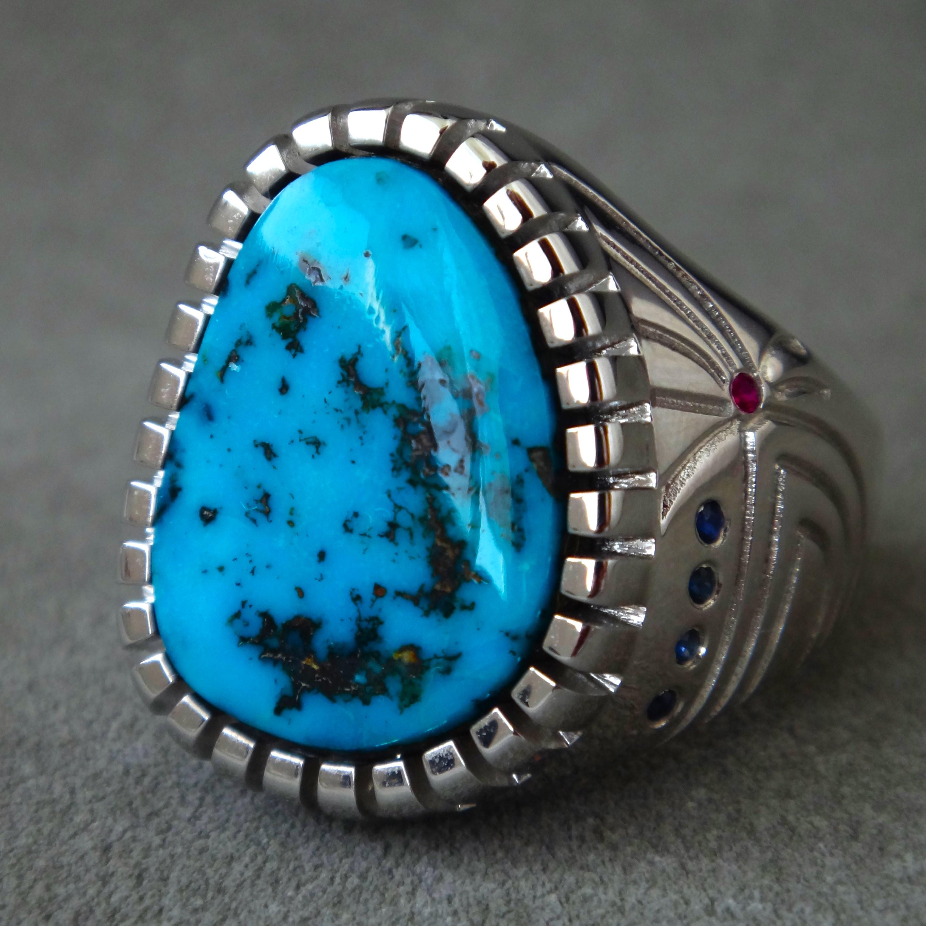 Natural Kingman Turquoise, 18K 
white gold, with small ruby and sapphire as the side matched. 

The ring size is 10#(US), the ring highness is 
23.5MM, the witness is 13.5MM, total weight is 16G.
Ithaca Peak turquoise comes from 
the Cerbat