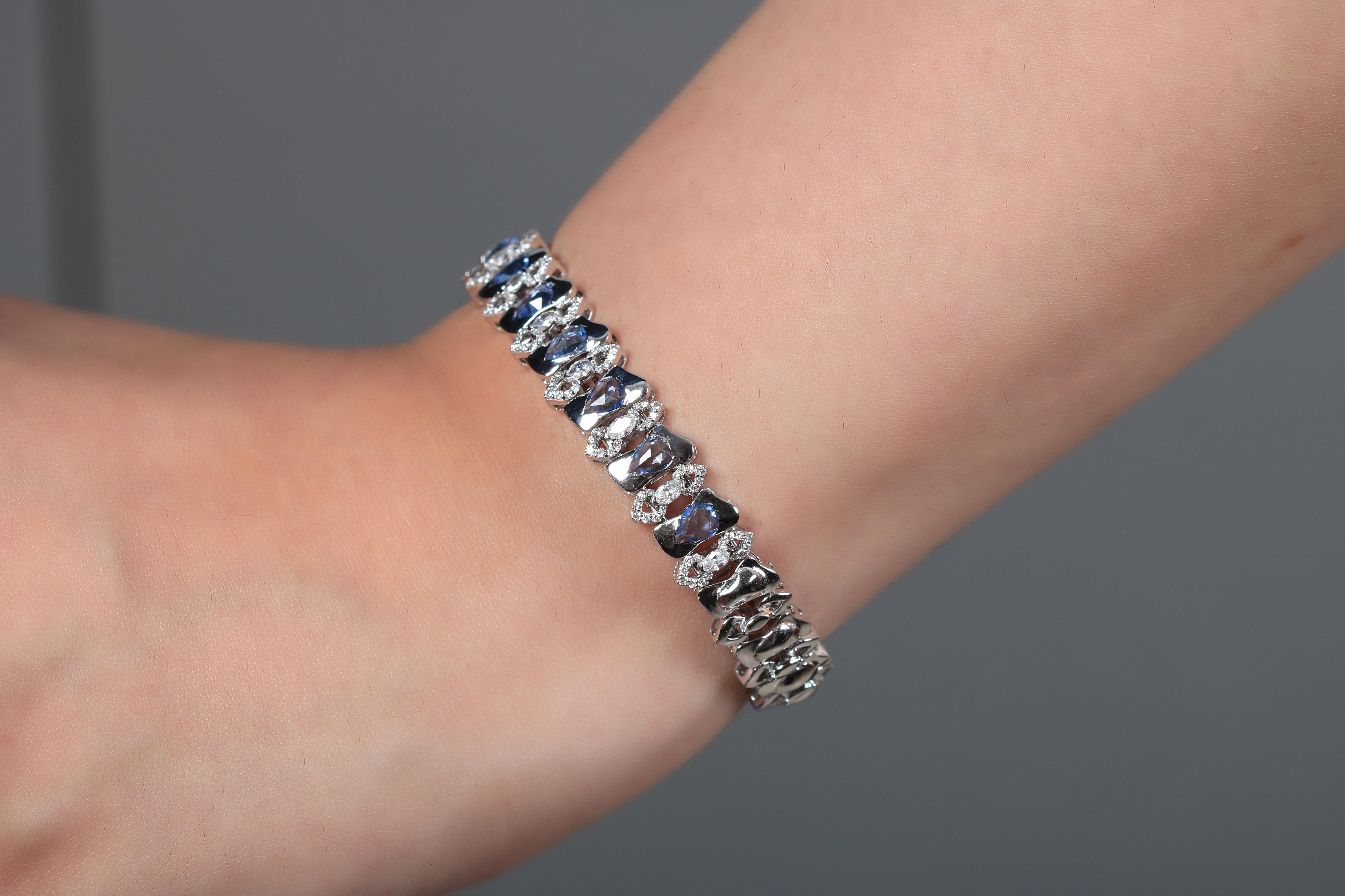 Dieses schlichte, aber hochexklusive Arabesque-Armband aus blauem Saphir ist charmant und prächtig und verkörpert die Essenz des wahren Luxus. Bemerkenswert sind die blauen Saphirsteine, die von einem Medley feiner Diamanten umgeben sind. Das
