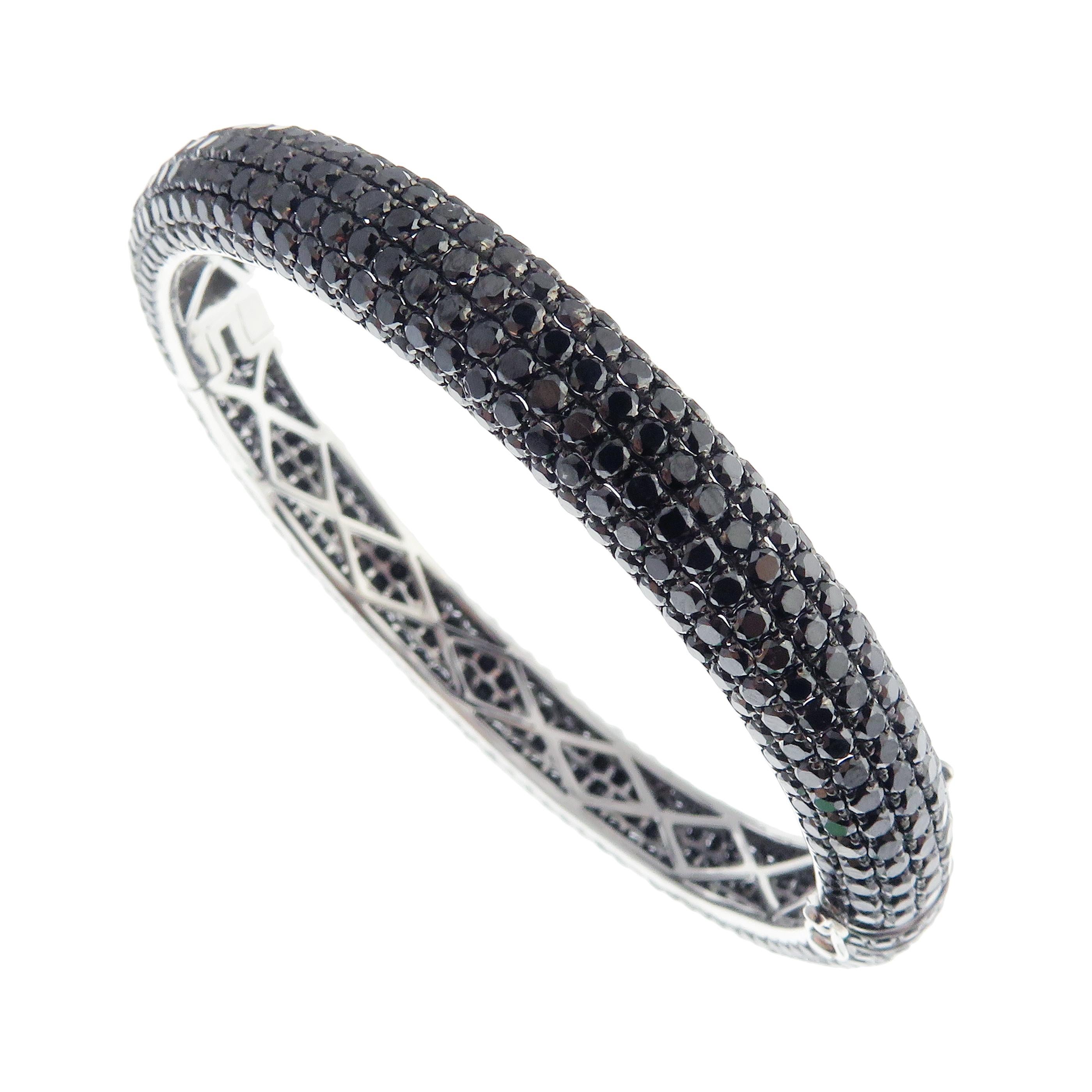 This classic pave bangle is crafted in 18-karat white gold, weighing approximately 22.90 total carats of black diamonds. This bangle has diamond all 

around for a 