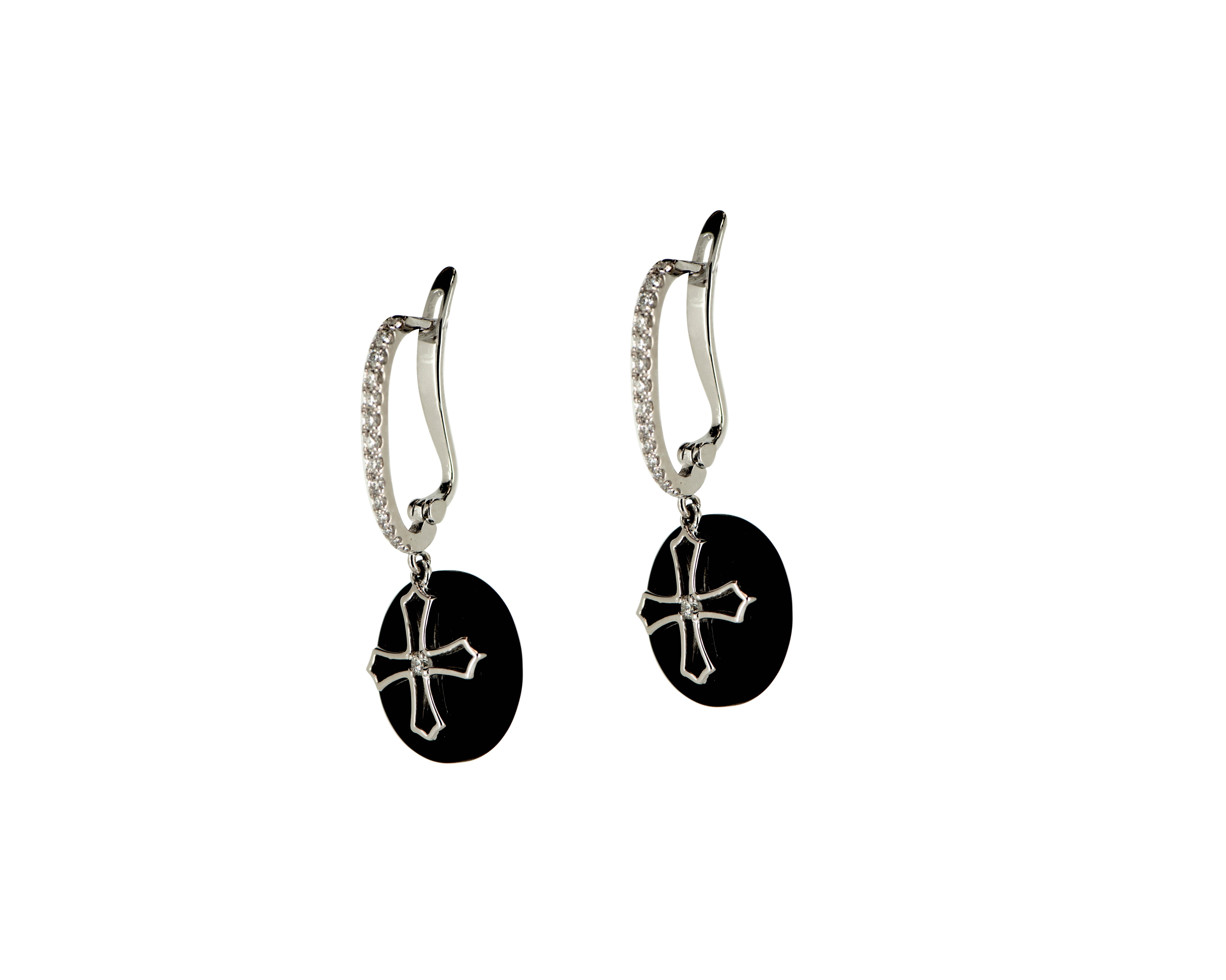 These 18 Karat White Gold Black Onyx Diamond Cross Dangle Earrings are a perfect representation of timeless elegance and sophistication. The sleek, black onyx gemstones make a bold statement and are beautifully accented by the sparkling .20ct of