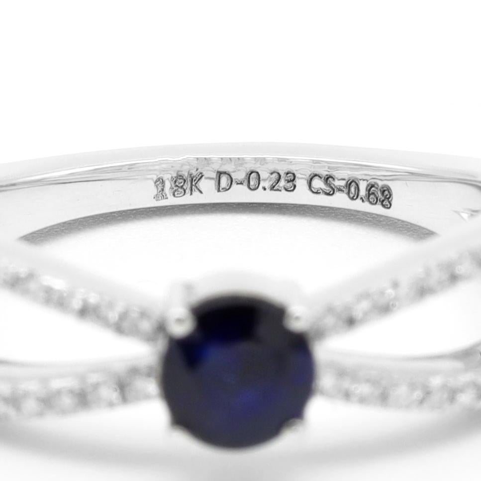 18 Karat White Gold Blue Sapphire Round-Cut and Diamond Ring

This oxford blue round solitaire sapphire ring is pure bliss. The round dark blue sapphire astutely placed in the bezel setting is intensified with the designer two-row criss-cross