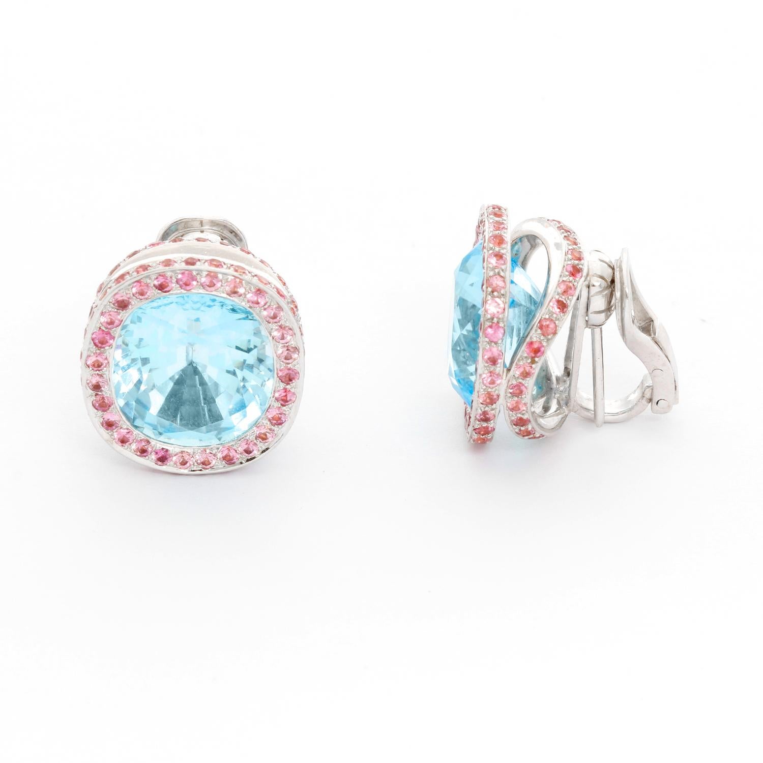18K White Gold Blue Topaz and Pink Sapphire Earrings - Gorgeous cushion shaped blue topaz earrings weigh a total of approx 23 cts and are surrounded by round cut pink sapphires. Sapphire total weight is approx 3.45 cts. The earrings are 3/4 inch by