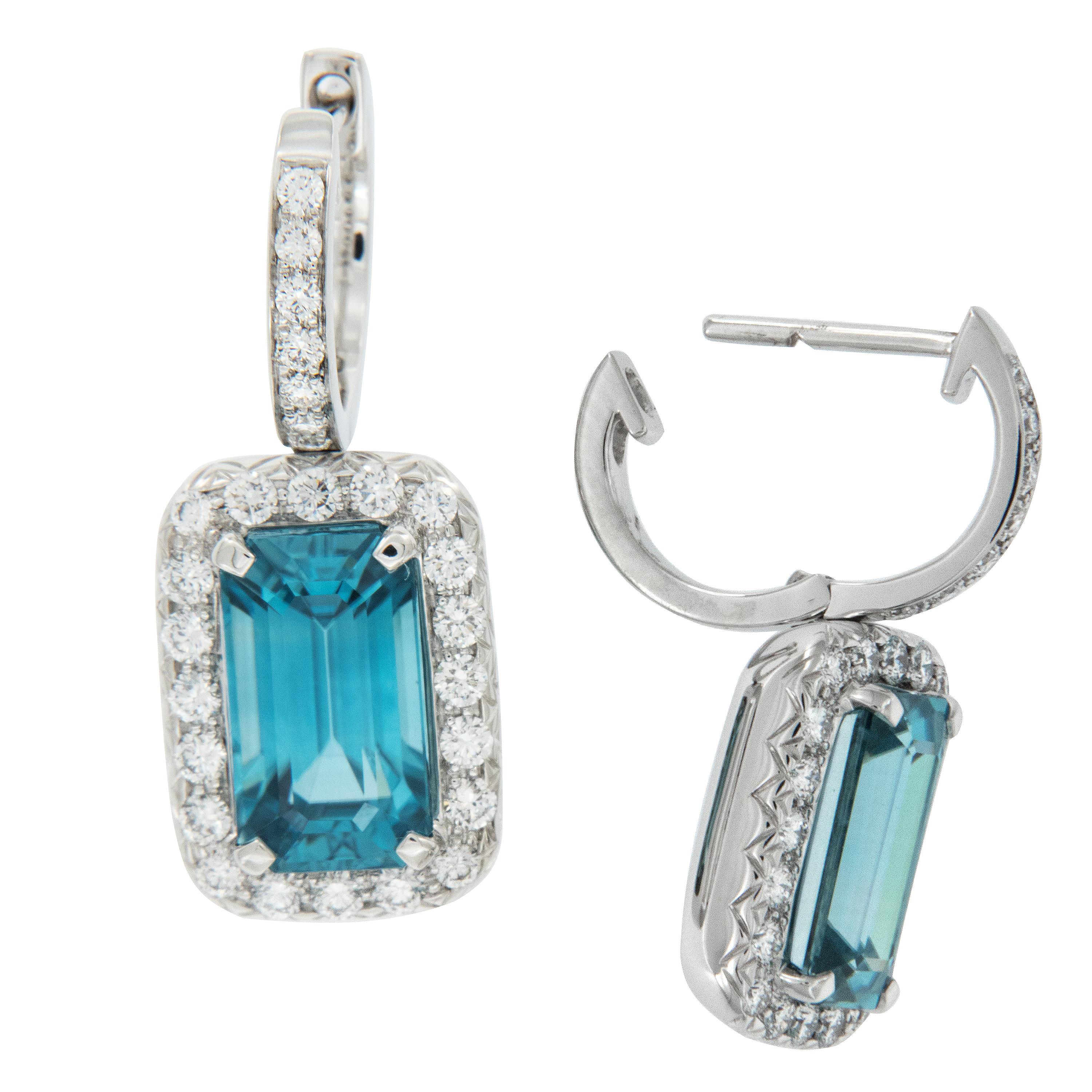 The vivid ocean blue of these exceptional blue zircons will transform you to a tranquil place! Expertly crafted in 18 karat white gold, these blue zircons (8.50 Cttw) are framed by 0.77 Cttw E-F color, VS clarity diamonds. Earrings dangle to catch