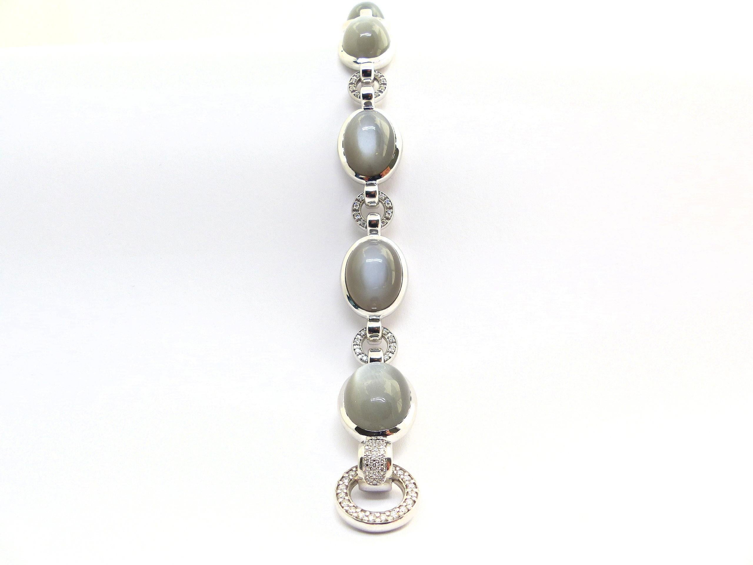 This 18k White Gold (38.5g) Bracelet is set with 6x fine Moonstone Cabouchons in anthrazit colour (oval, 16x12mm, 55,30ct) + 114x diamonds (brillant-cut, 1.0-1.5 mm, G/VS, 0.94ct). 

Length: 19.5cm.