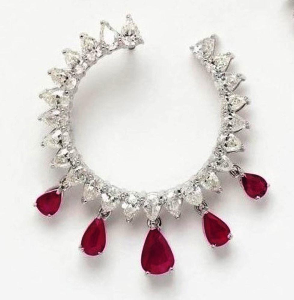 These everyday wear earclips are simple and classic. Finely calibrated brilliant cut diamond pears are set in prongs in these front to back ear clips. Pear shape natural ruby drops sit on the bottom and are made to be flexible. These earclips are