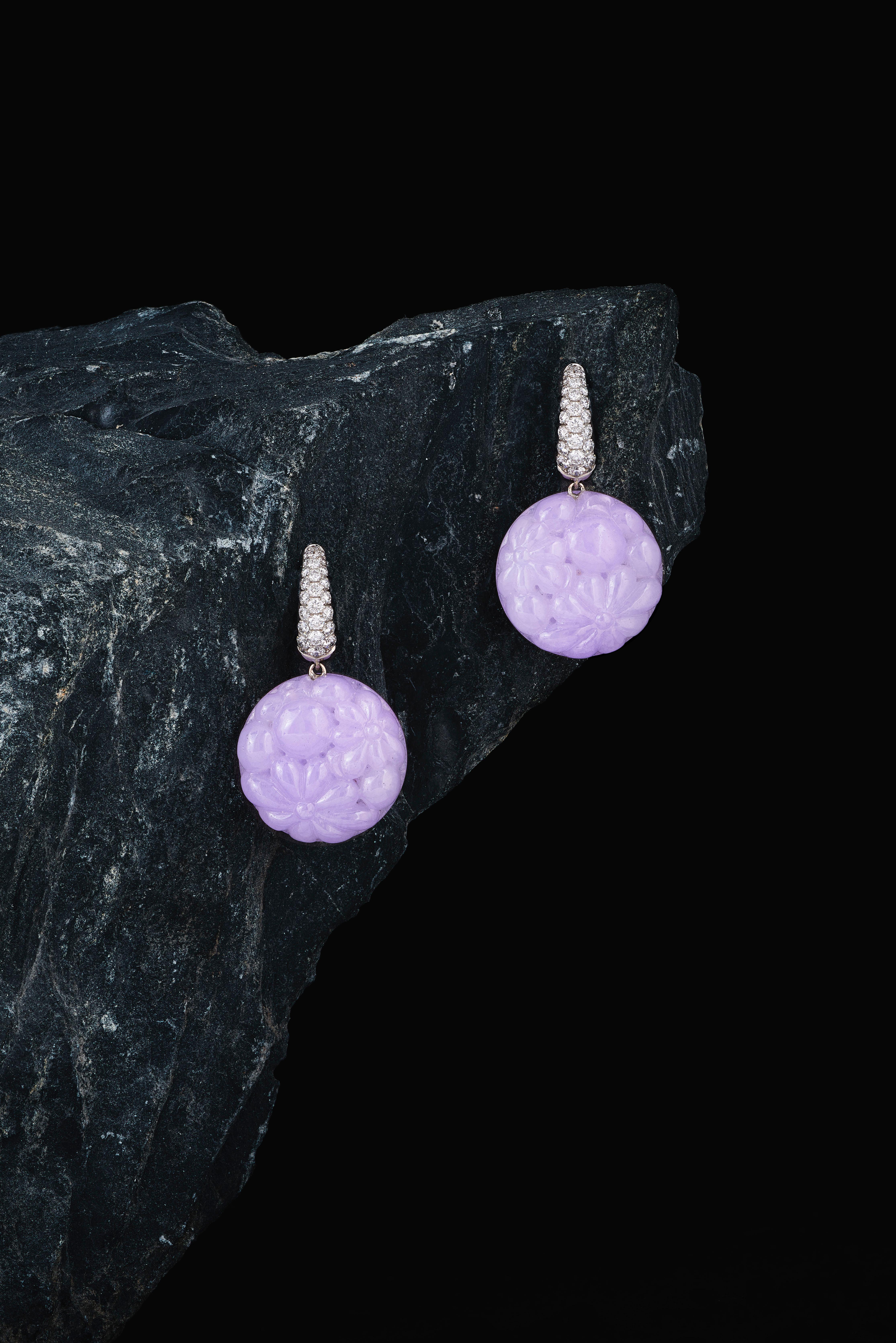 These one-off earrings are handmade in Switzerland. The earrings are made in 18K white gold with two creoles with 50 Diamonds of total 0.61 ct. F vvs and and two carved Jade discs of together 36.11 ct. in a lovely lavender color. 
You can expect the