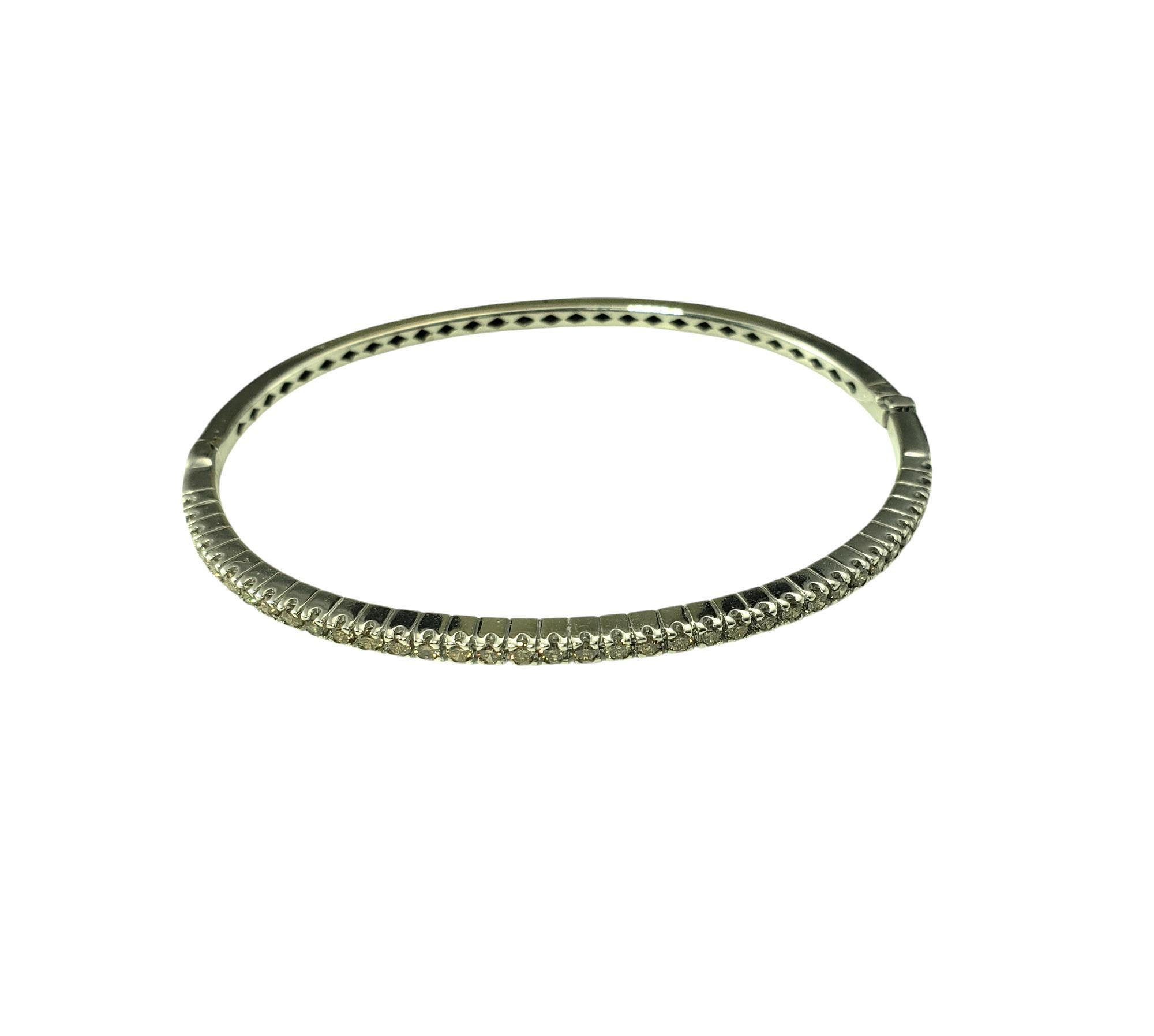 18 Karat White Gold Champagne Diamond Bangle Bracelet-

This 18K white gold bangle bracelet is a stunning fusion of elegance and modern luxury, featuring a row of 26 champagne diamonds that add a warm radiant glow. Hinged closure. Width: 3