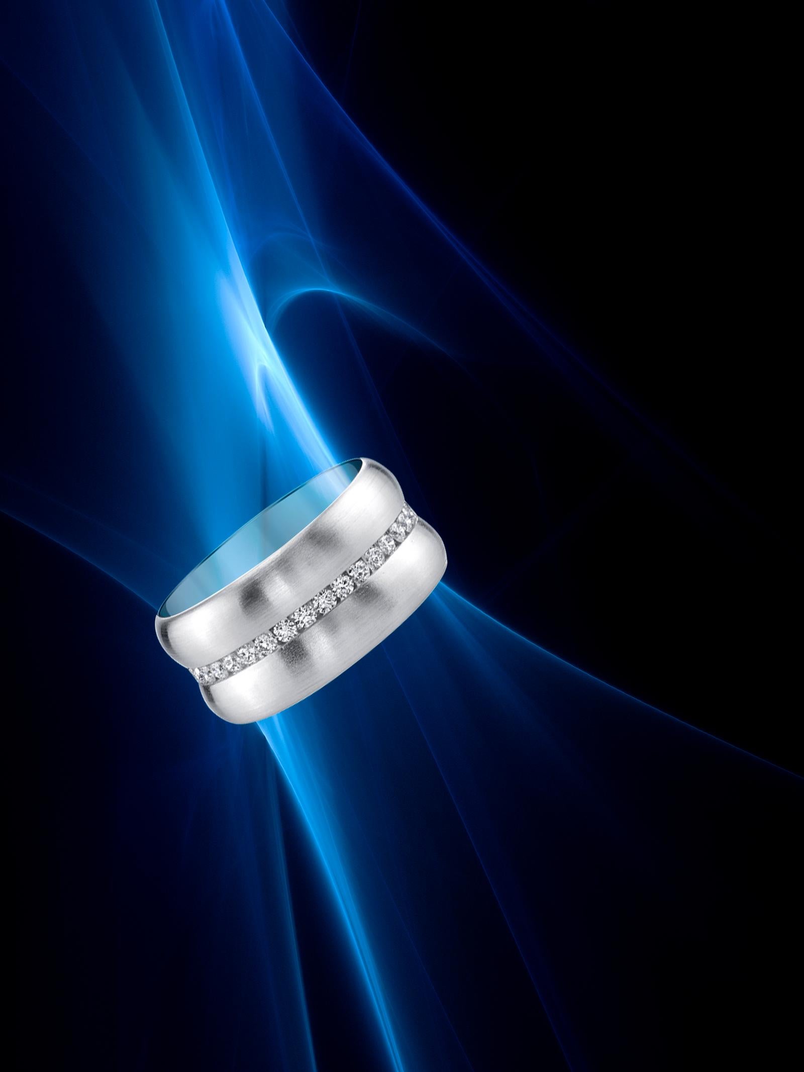 Crafted to appeal to the fashion-conscious woman concerned with excellence and taste, this ring is both sensual and practical for everyday wear. The band is 18 Karat White Gold and is accented with 0.80 CT Channel Set Diamonds. Measurements: Width: