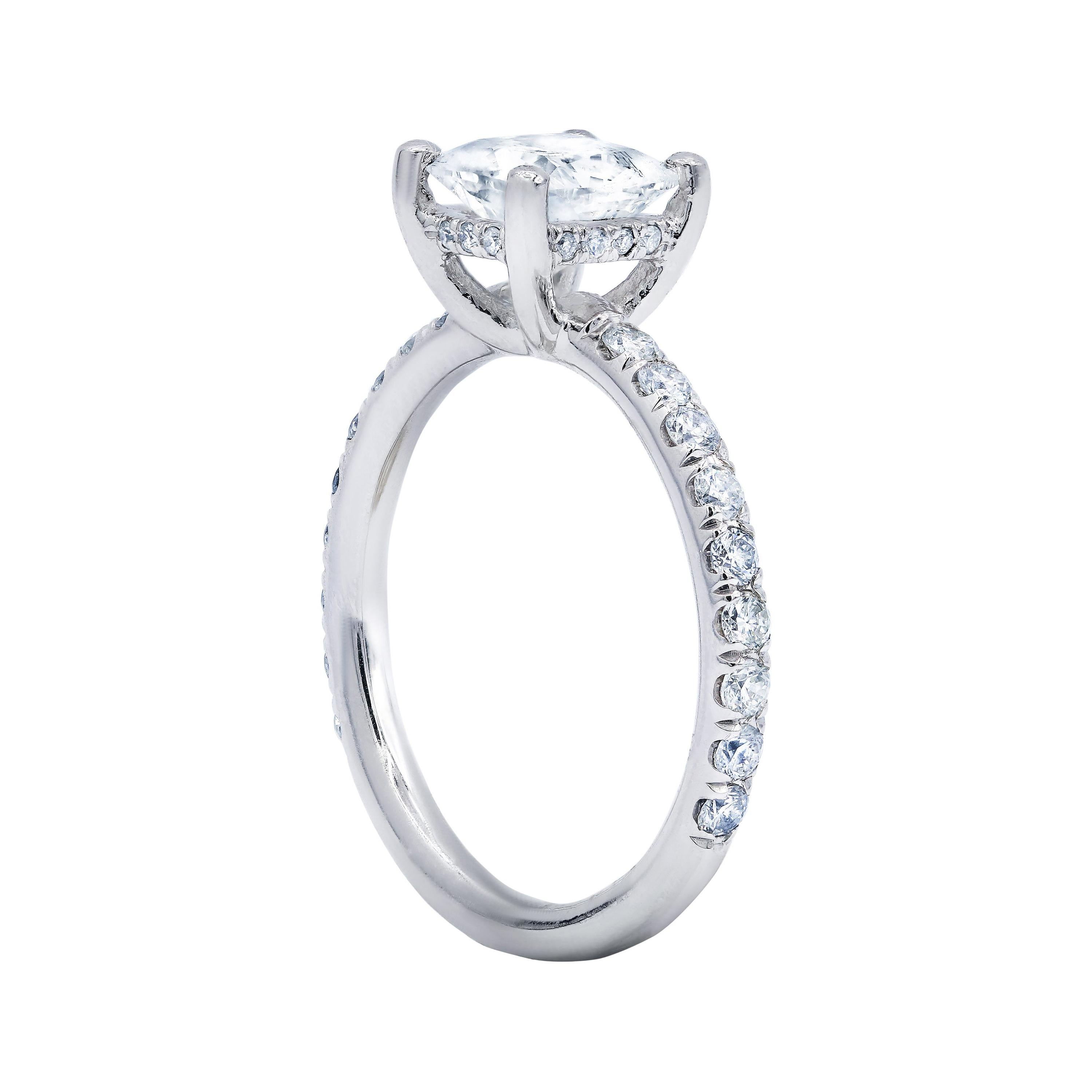 18 karat white gold classic diamond engagement ring features 1.06 carat clarity enhanced cushion cut diamond in the center and surrounded by additional 0.30 cts round diamonds on the side.
