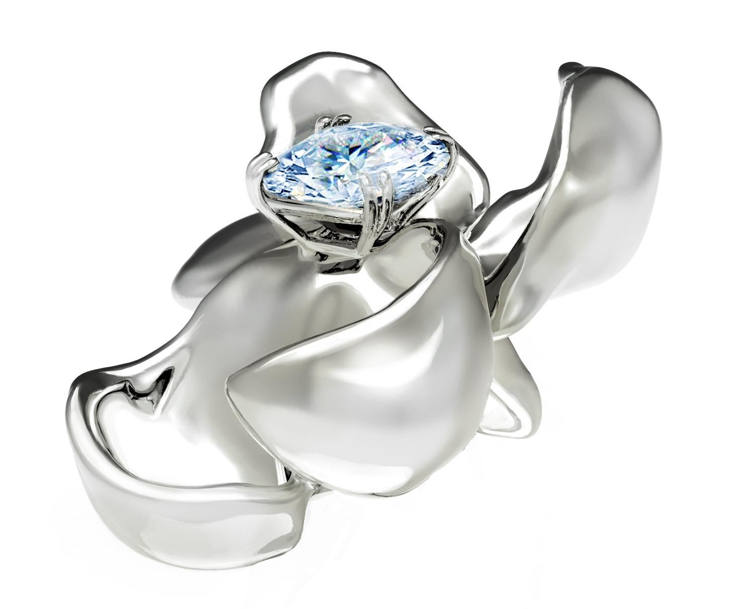 This Magnolia Flower contemporary brooch is in 18 karat white gold with clear and shiny light blue sapphire, 0.65 carats. The water-surface of the gem multiplies the light, mirroring on the golden petals. The weight is 8.5 gr. The ring from this