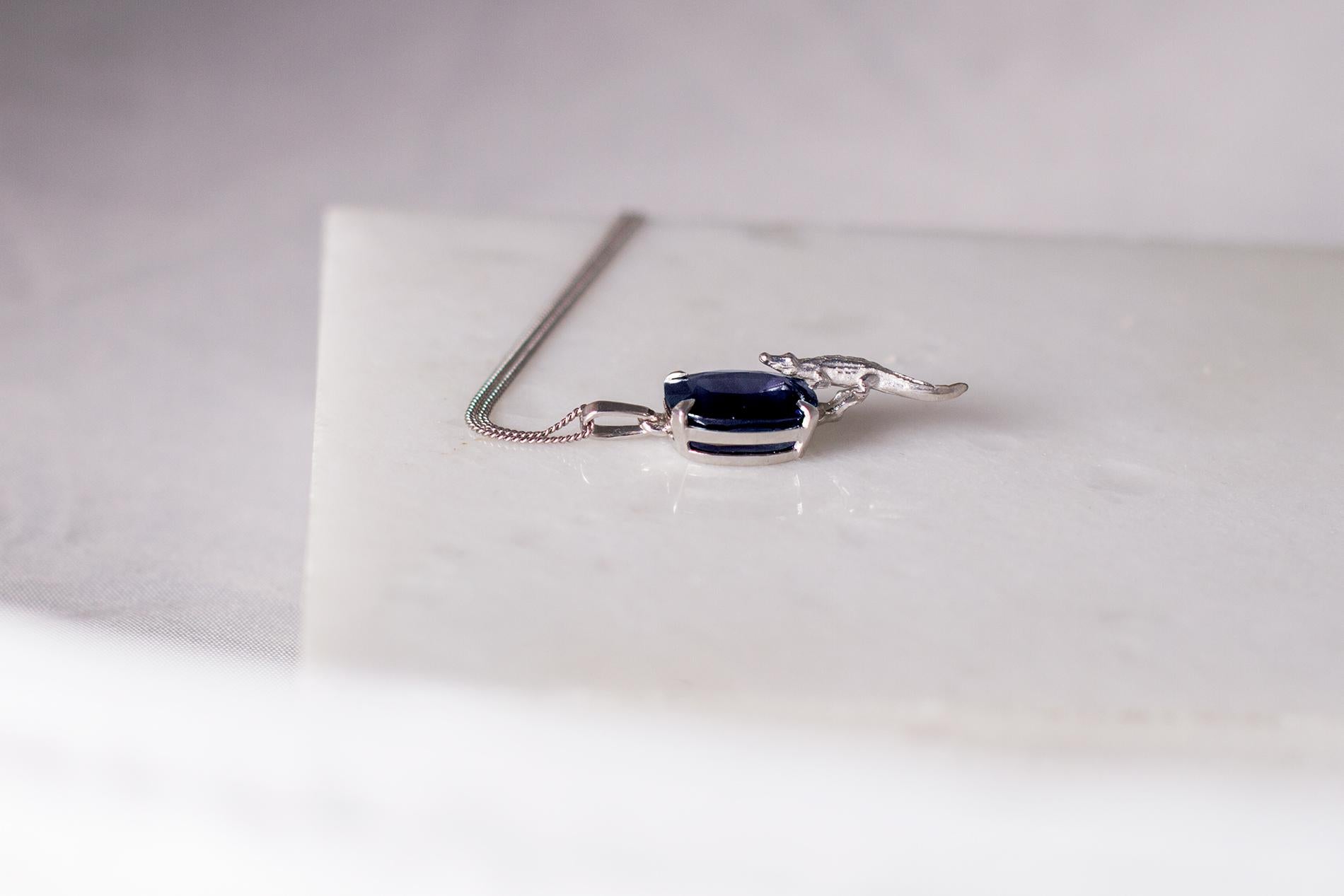 This 18 karat white gold crocodile model pendant necklace is encrusted with 4.32 carats natural dark blue cushion sapphire, 12.8x8.5 mm. The gem catches eye's attention and well designed in contemporary design pendant necklace.

You can order this