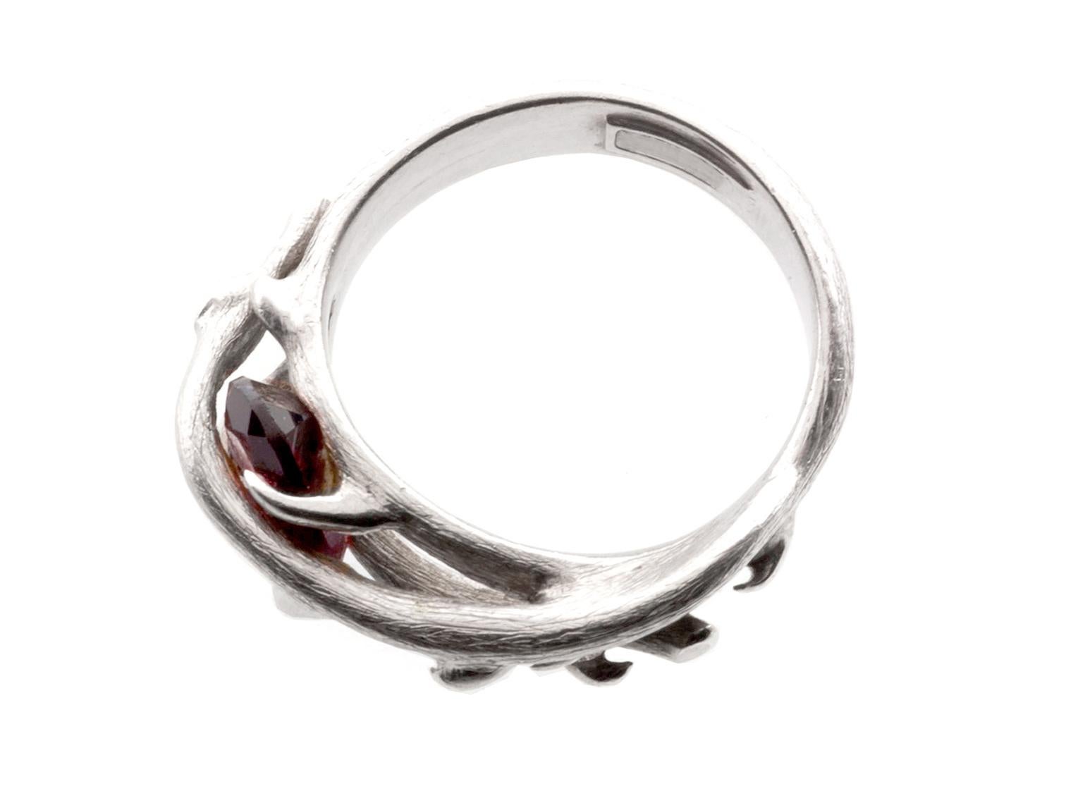 This contemporary Wild Rose ring in 18 karat white gold belongs to the Rose collection. The item was featured in Harper's Bazaar UA magazine. 

The ring has wood texture and unusual gem placement. The garnet gem is 8x6 mm. It  was inspired by the