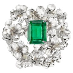 Zeitgenössischer floraler Smaragd-Verlobungsring aus Weißgold mit sieben Diamanten