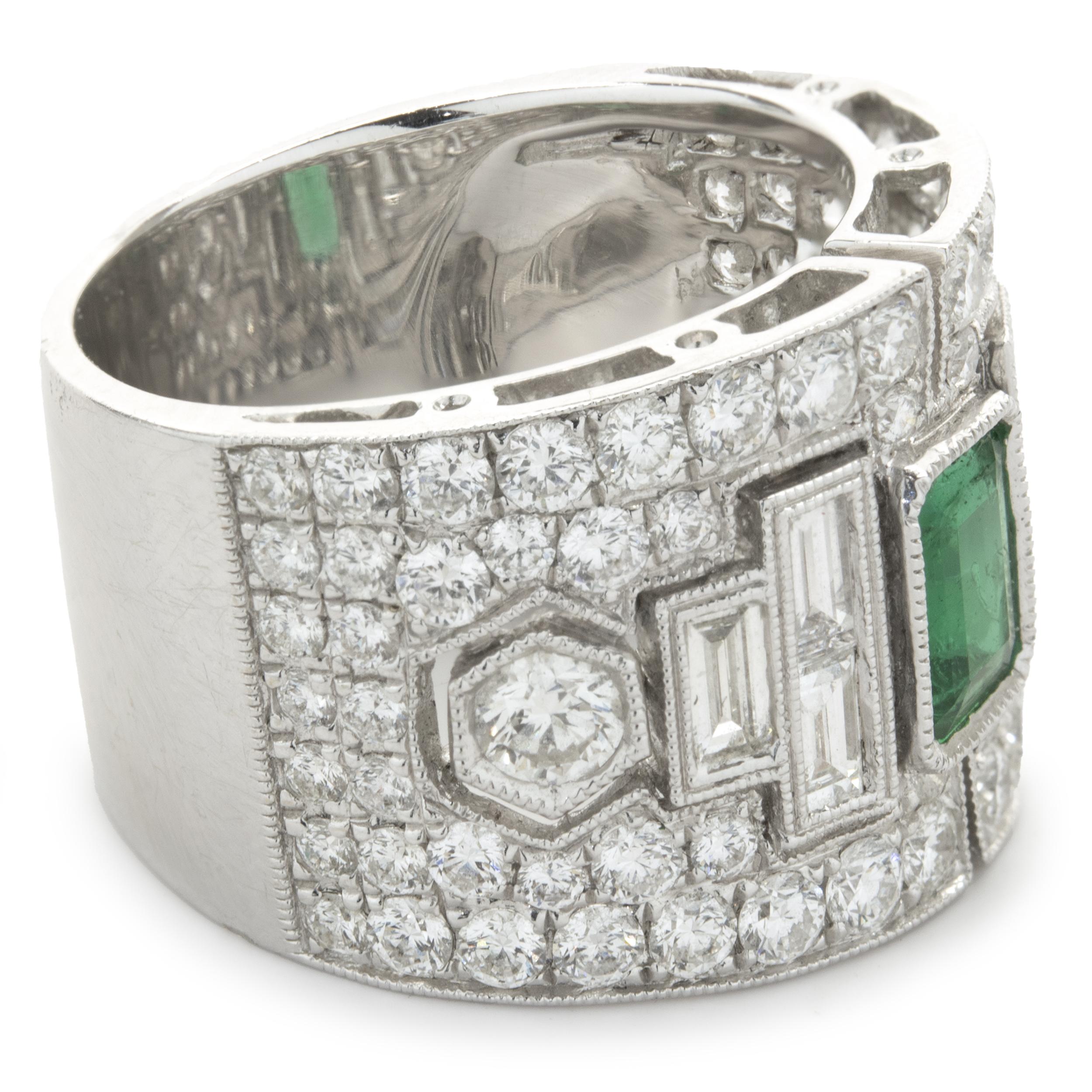 Designer: custom
Material: 18K white gold
Emerald: 1 emerald cut = 0.65ct
Color: Kelly Green
Clarity: AA
Diamond: 74 round brilliant cut = 2.14cttw
Color: G
Clarity: VS2
Diamond: 6 baguette cut = .65cttw
Color: G
Clarity: SI1
Dimensions: ring top