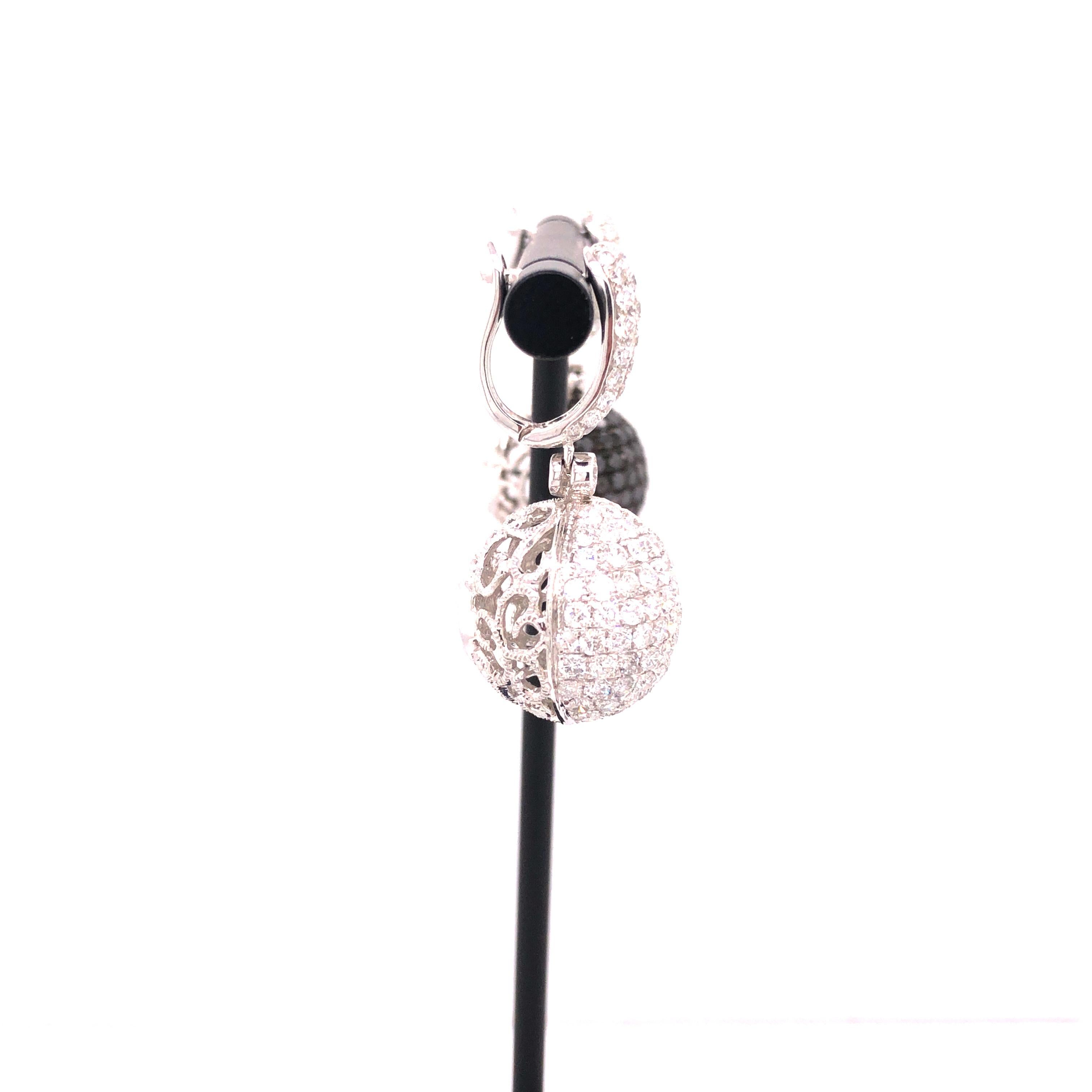 A pair of ball dangle earrings featuring round-cut diamonds weighing a total of 3.31 carats, and round-cut black diamonds weighing a total 2.27 carats, all set in 18K white gold.