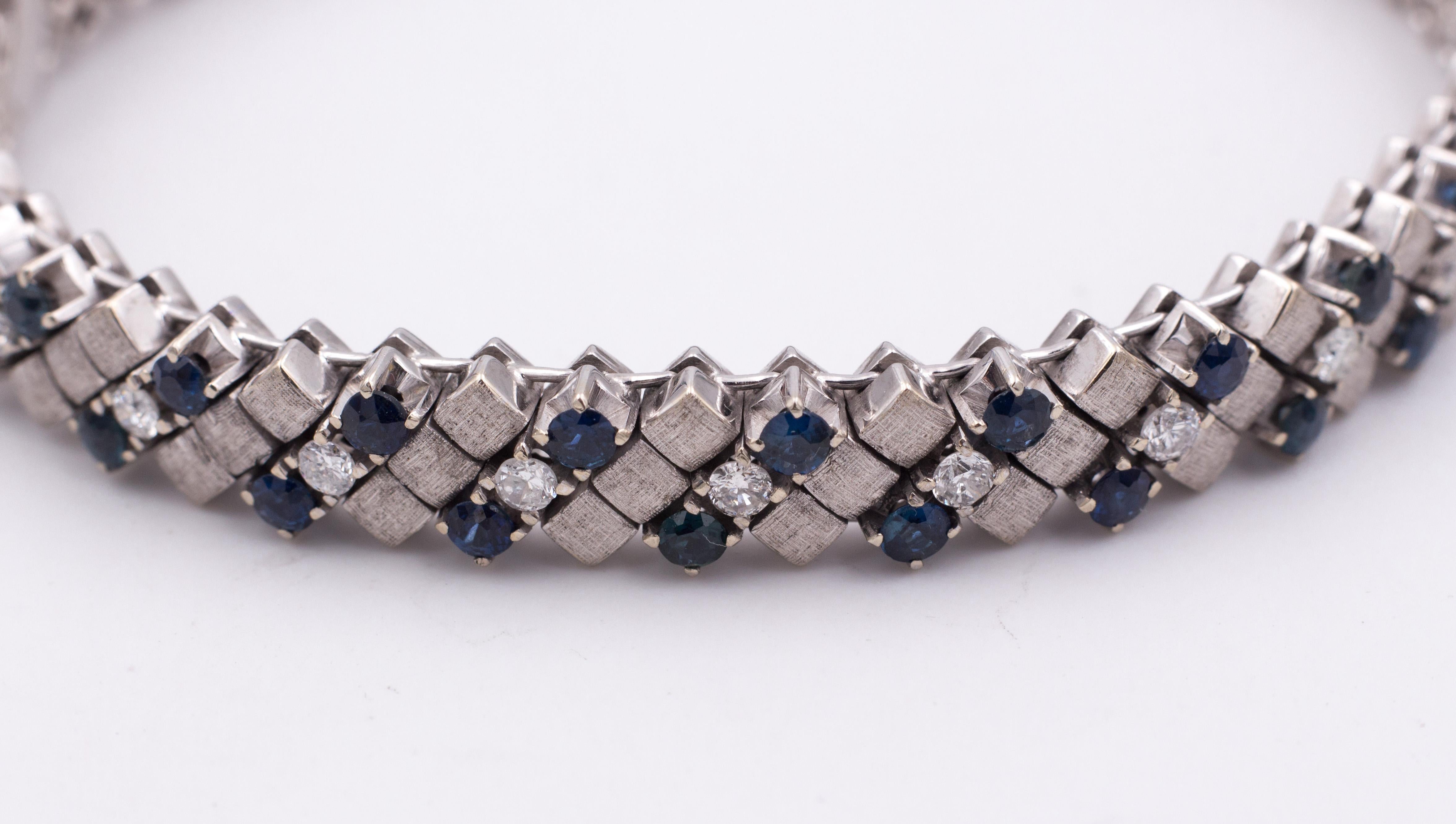 This modern bracelet, crafted in 18K white gold throughout, is set with a series of three-row stones, with two sapphires and a round cut diamond, alternating to a three-row gold squares. 
The sapphires are for a total of 3.9ct ca., and the diamonds