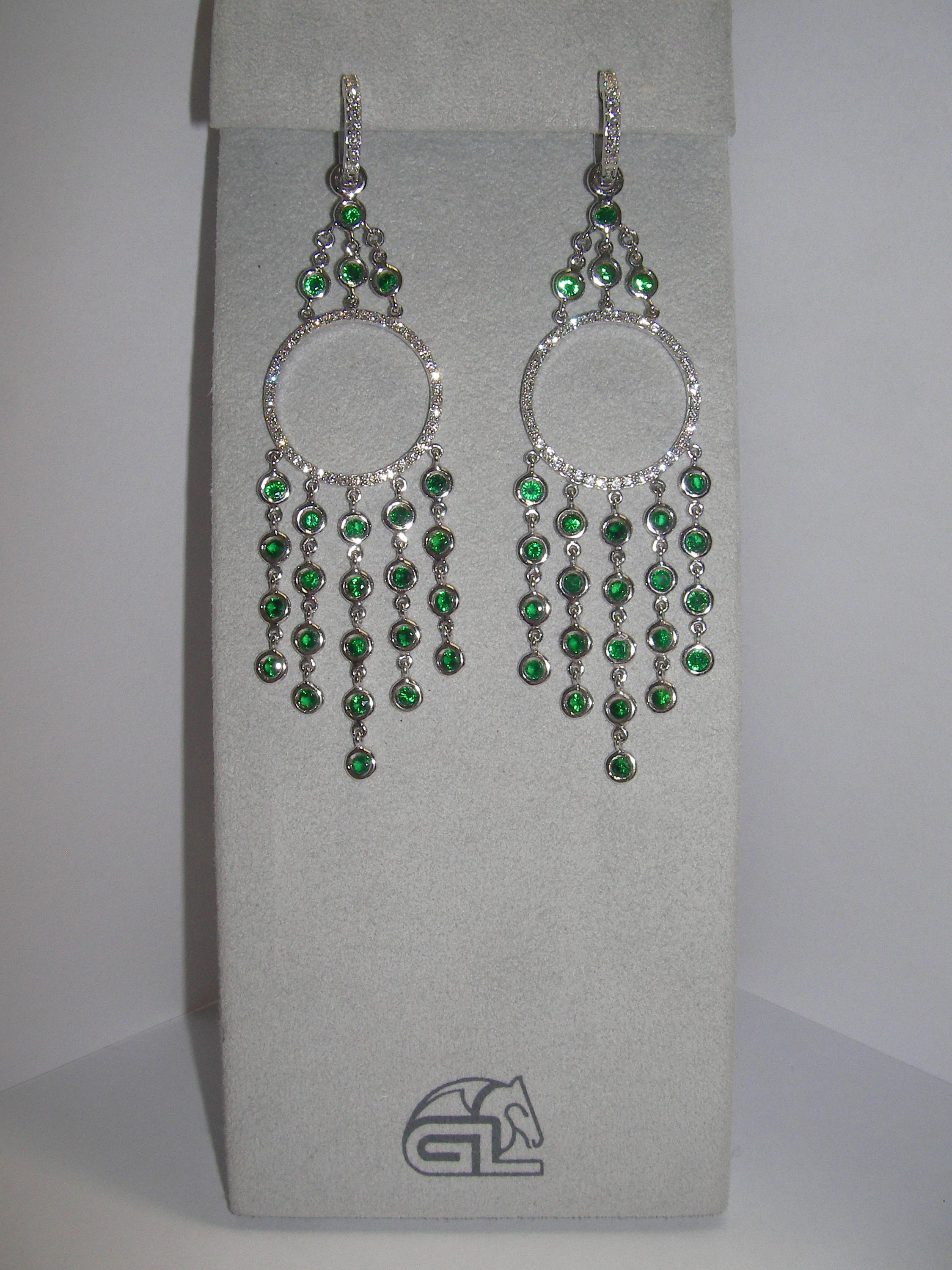 These 18 Karat White Gold Dangle Earrings combine the perfect elements of a retro, yet contemporary design. Each piece holds a variety of vivid Tsavorite stones and round Diamonds. This set is the missing piece for your next beautiful evening