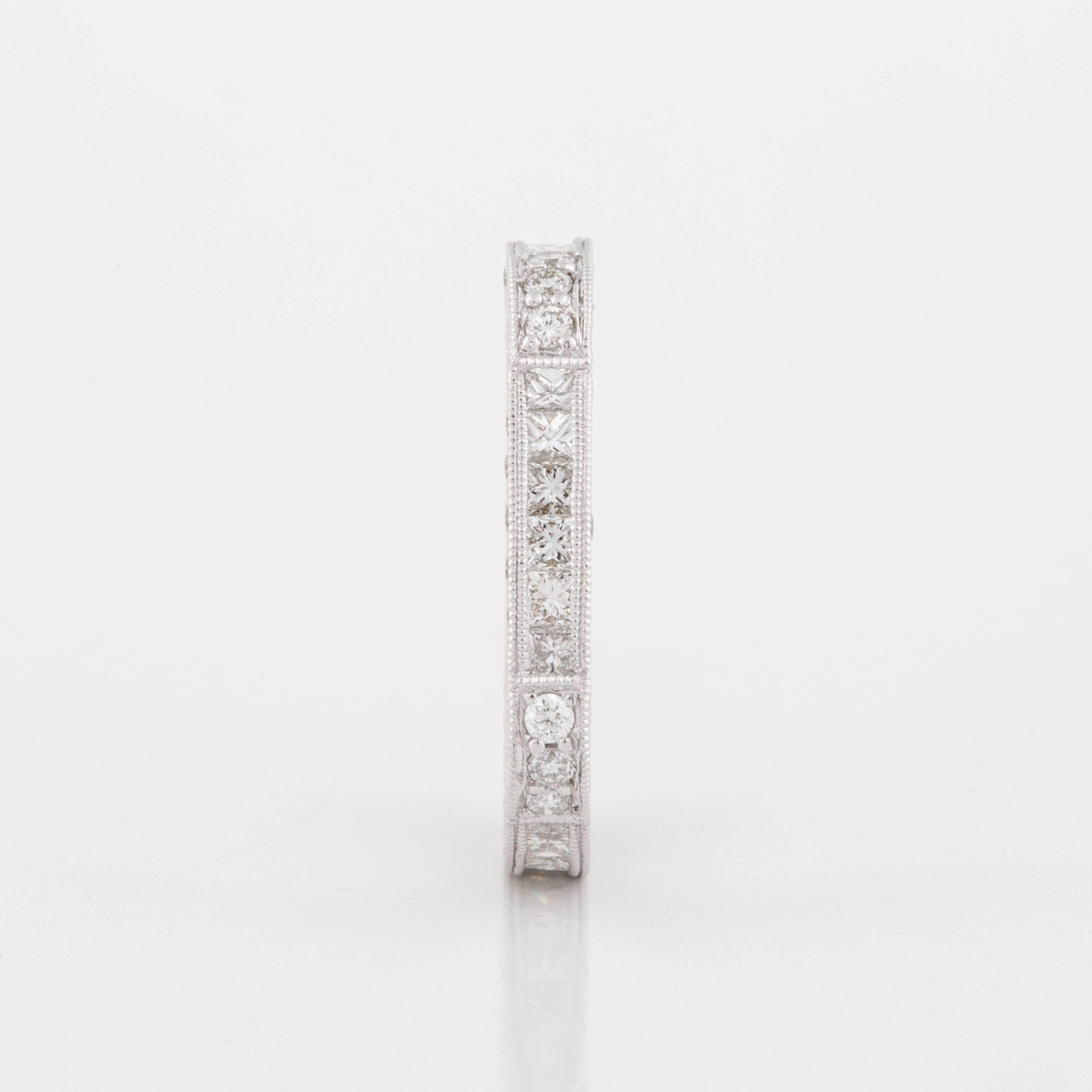 Eternity band composed of 18K white gold with 18 princess-cut diamonds and 42 round brilliant-cut diamonds; G-H color and VS1-2 clarity, with a total carat weight of 2.60.  The band features millegrain work as well as a more squared shape.  It is