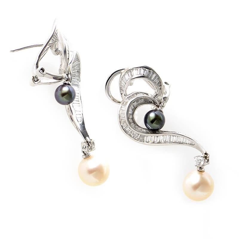 This pair of drop earrings are gorgeous and feminine. They are made of 18K white gold and are set with ~2.62ct of diamonds. Lastly, the earrings each boast a dangling black and white pearl.

