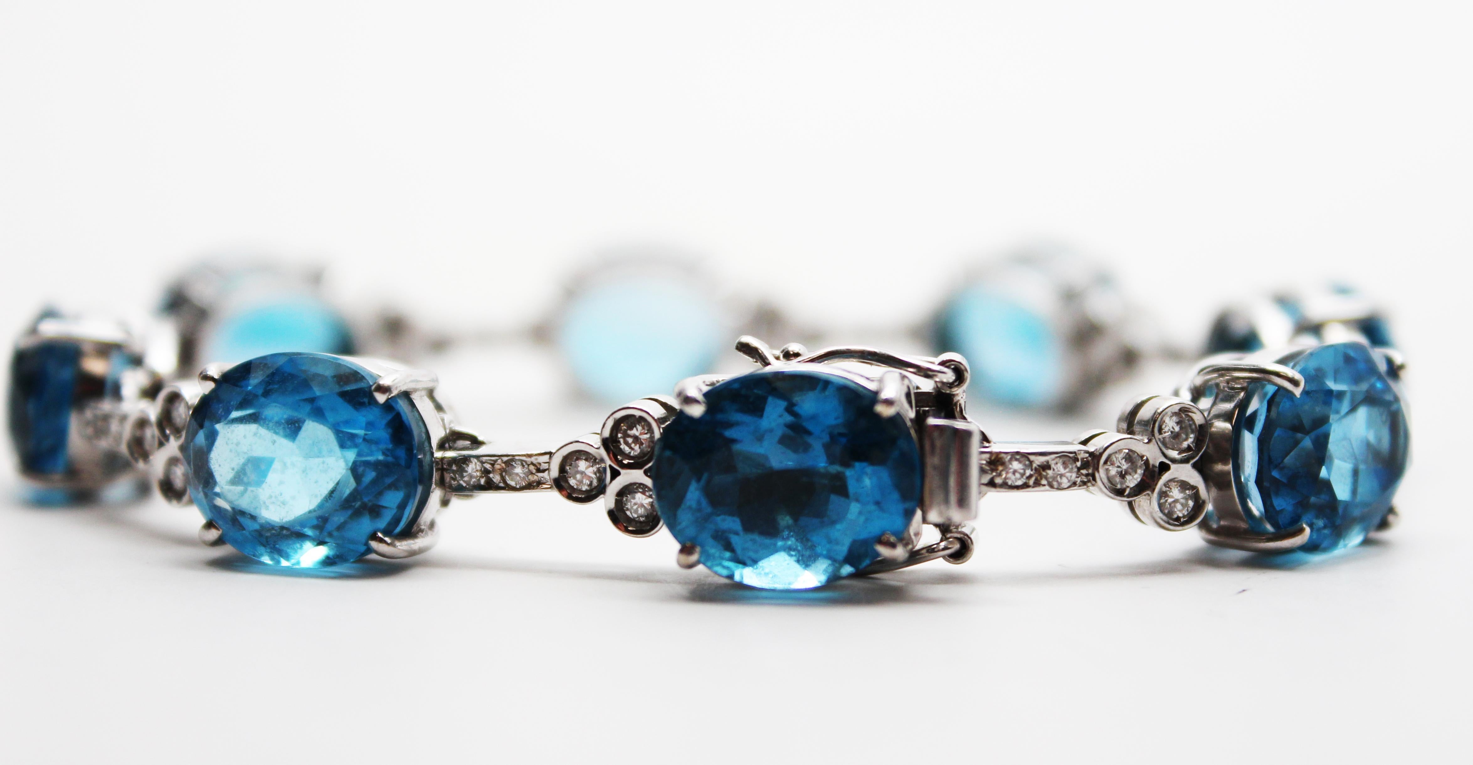 This is a gorgeous bracelet in 18k white gold featuring brilliant white diamonds and lovely blue topaz! The elegant layout of the bracelet features eight oval blue topazes separated by a diamond-set link. Each link is set with five gorgeous round