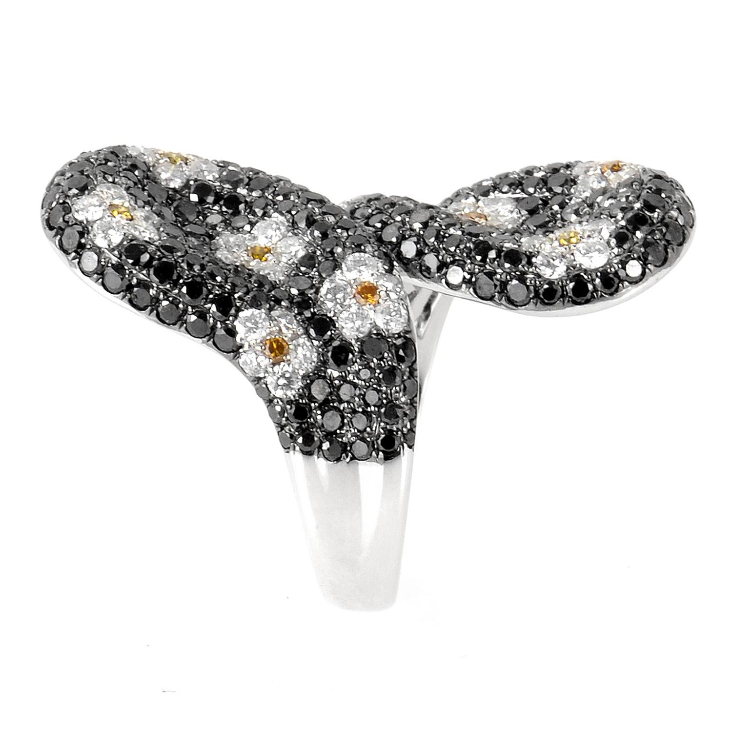This ring is opulent and shines with diamonds. This fabulous ring is made of 18K white gold and is set with ~4.18ct of black, white and yellow diamonds that form a lovely daisy motif on the ring. 