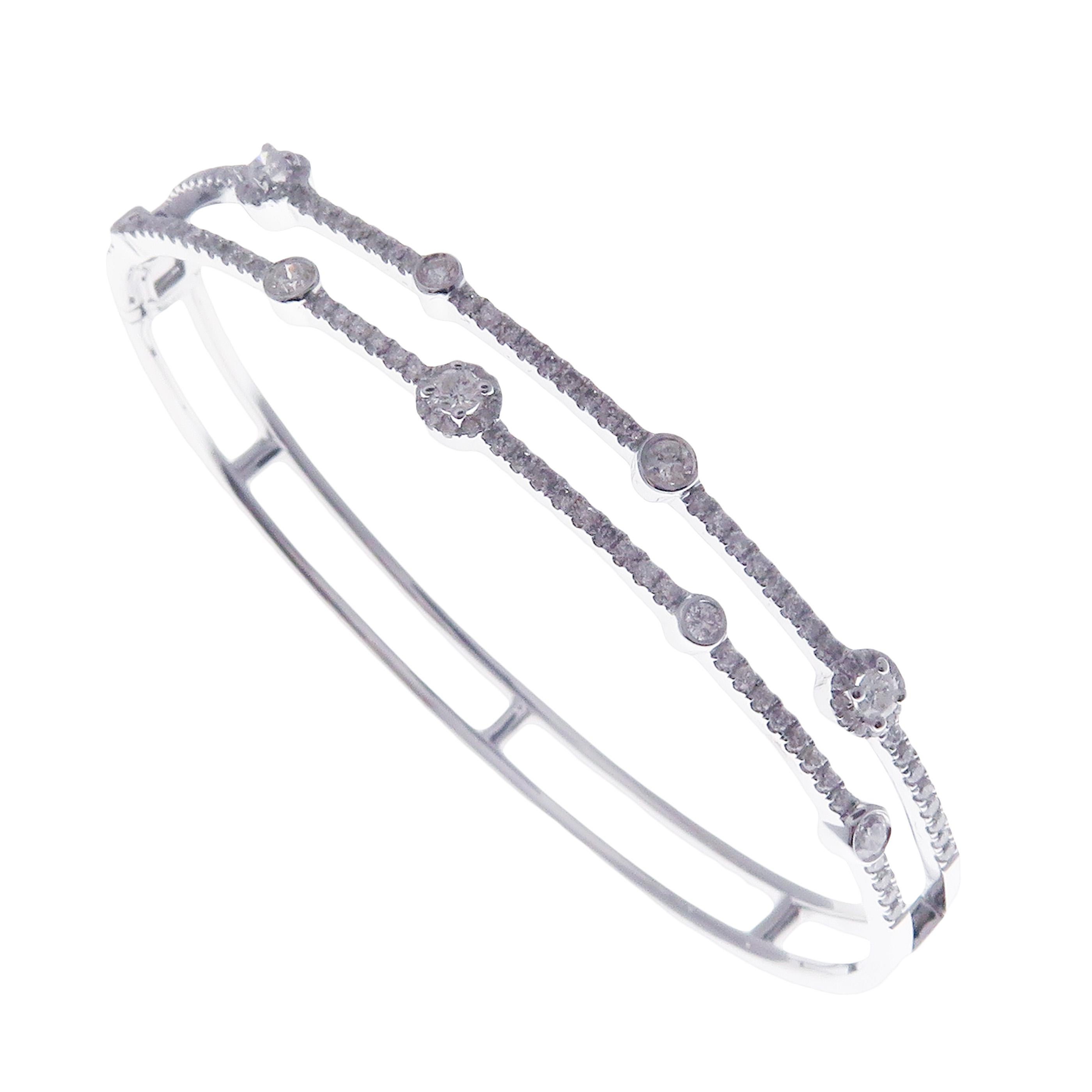 This delicate double-row baguette bangle is crafted in 18-karat white gold, weighing approximately 1.19 total carats of SI Quality white diamond. Hidden side clasp closure.

Fits wrists up to 6.50