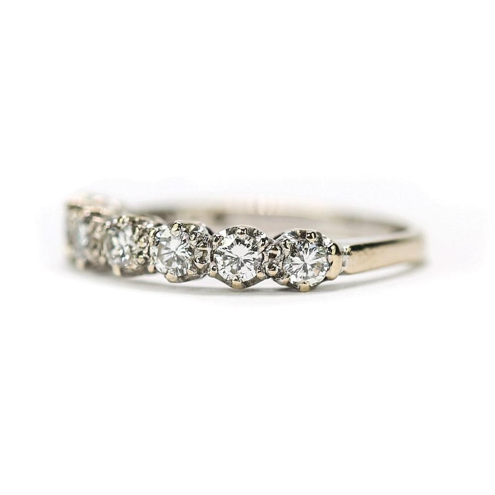 An attractive vintage 18k white gold diamond half eternity ring. The ring consists of a row of seven claw set diamonds each approx 0.10cts with an estimated total weight for the ring as 1.00cts. All the stones are set close together giving a