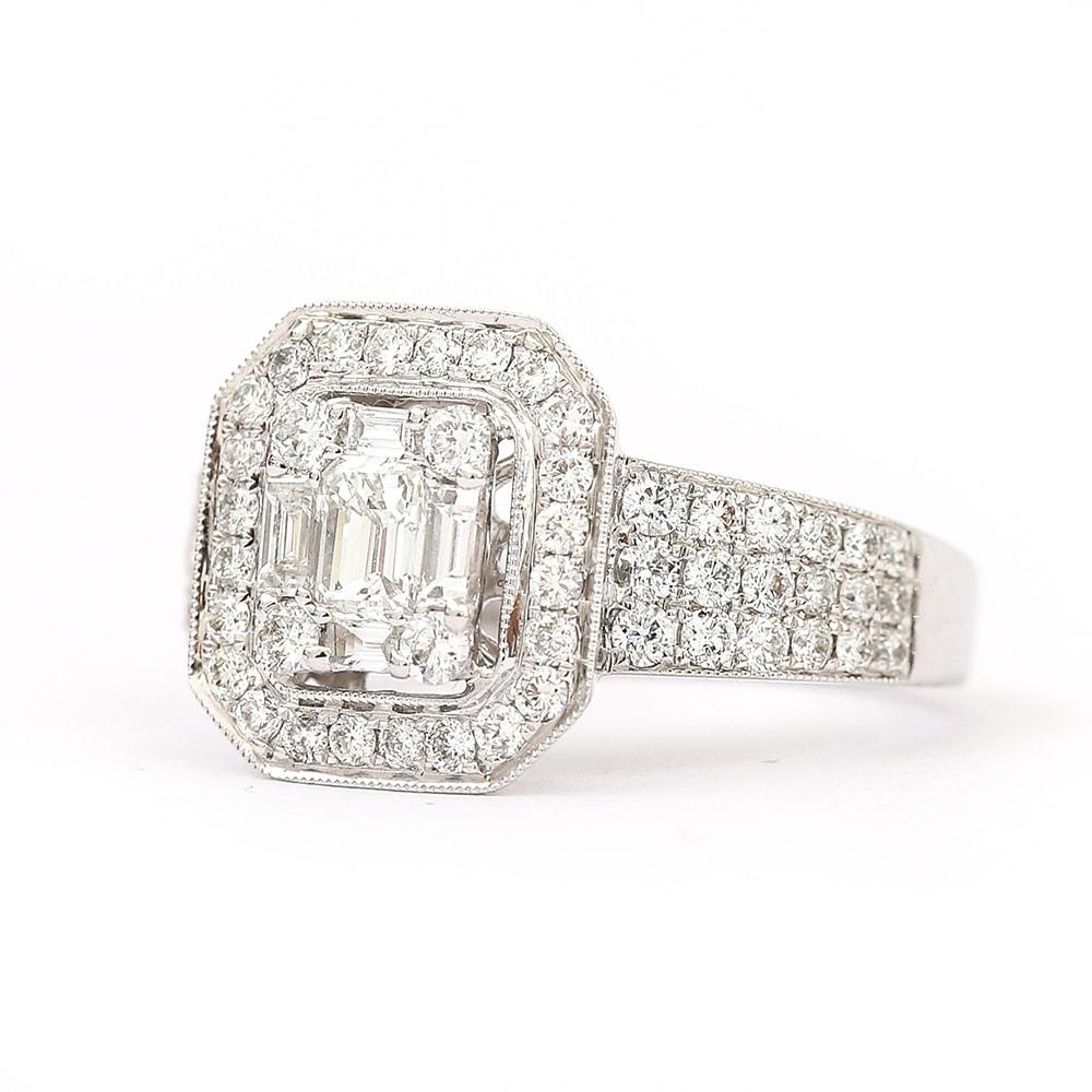 A modern diamond 18k white gold ring consisting of a total of 1.32cts of diamonds to include a centre est. 0.30cts emerald cut stone surrounded by brilliants & baguette cut diamonds of 1.00ct. Other pave set stones surround the mount making a total