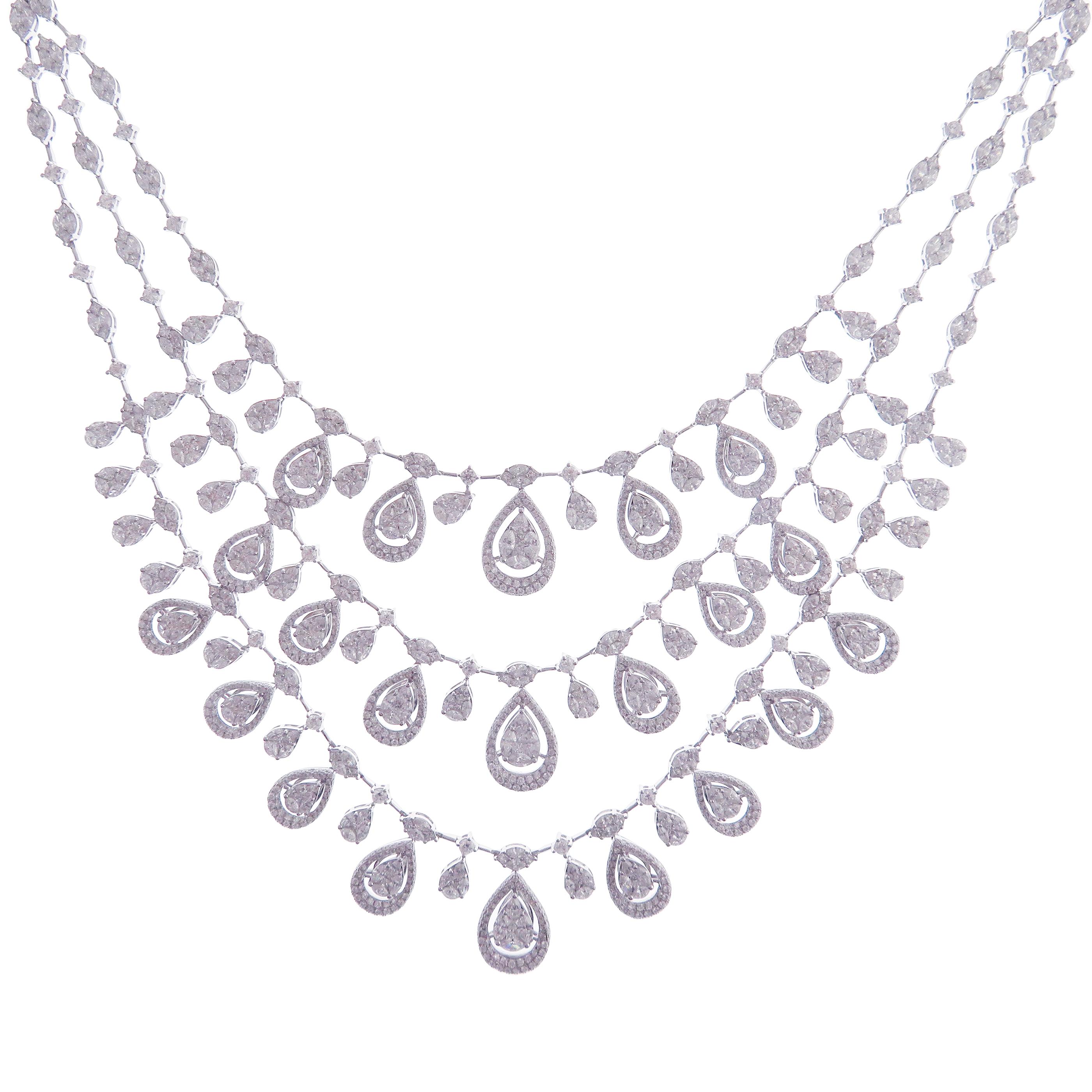 This fancy triple strand necklace is crafted in 18-karat white gold, weighing approximately 29 total carats of V Quality white diamond. These are very comfortable, flexible, and lay flat. This necklace is created with beautiful princess cut, pear
