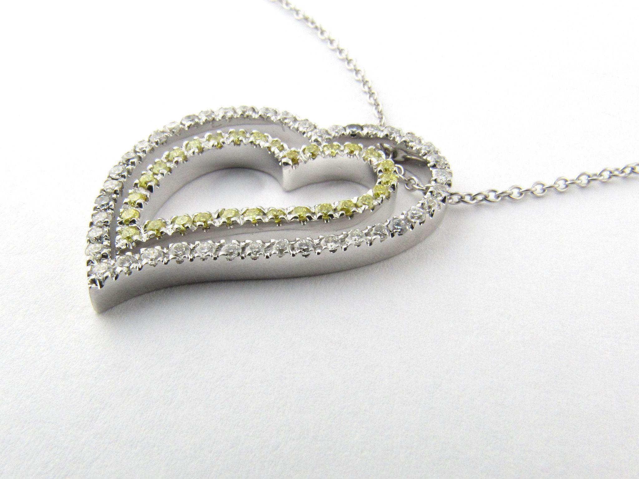 Ciondolo a cuore d'epoca in oro bianco 18 carati con diamante naturale bianco e giallo trattato. 

Questo splendido pendente presenta un doppio cuore con 42 diamanti bianchi taglio brillante e 29 diamanti gialli taglio brillante su una catena in oro