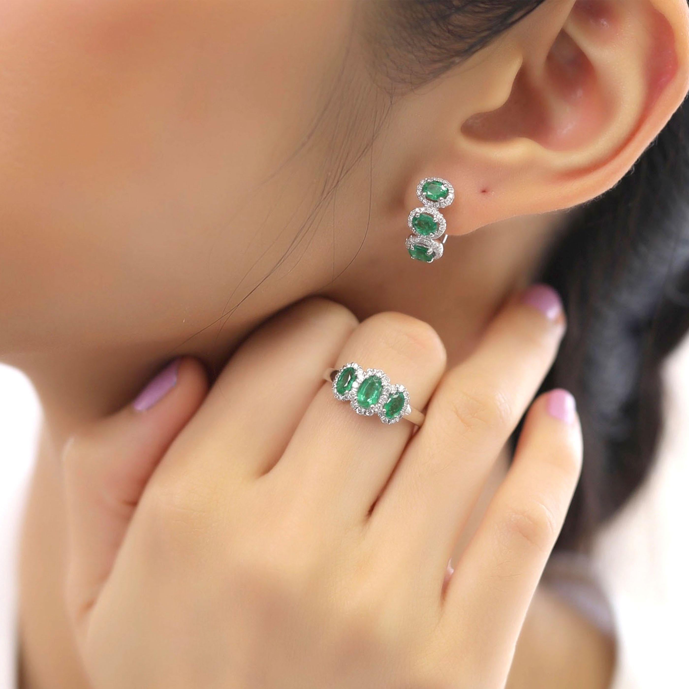 This emerald huggy earring and ring set is crafted in 18-karat white gold, weighing approximately 0.60 total carats of SI-H Quality white diamonds and 2.08 total carats of emerald stones. The ring is comfortable and can be sized 
