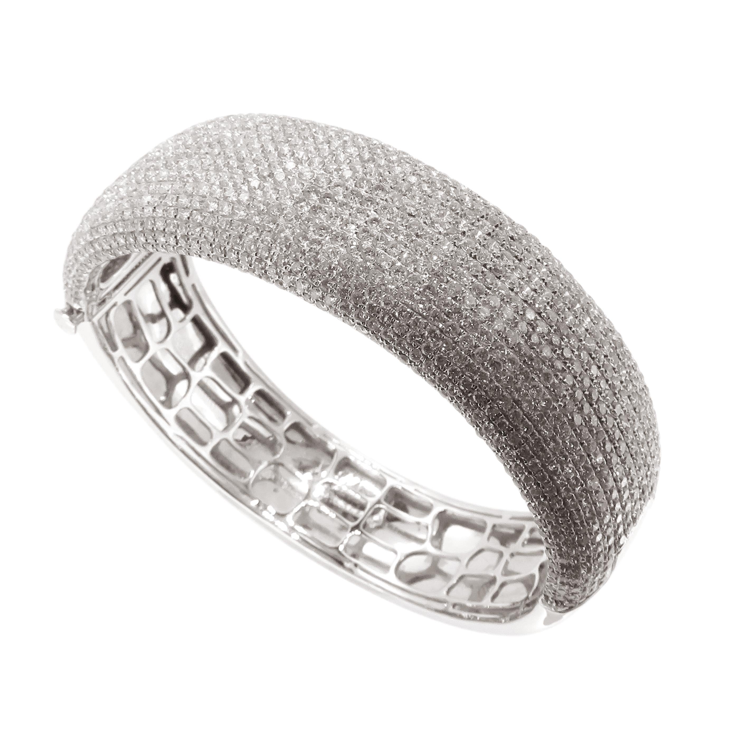 This pave bangle with is crafted in 18-karat white gold, weighing approximately 11.47 total carats of V-Quality white diamonds half way around. 

Fits wrists up to 6.50
