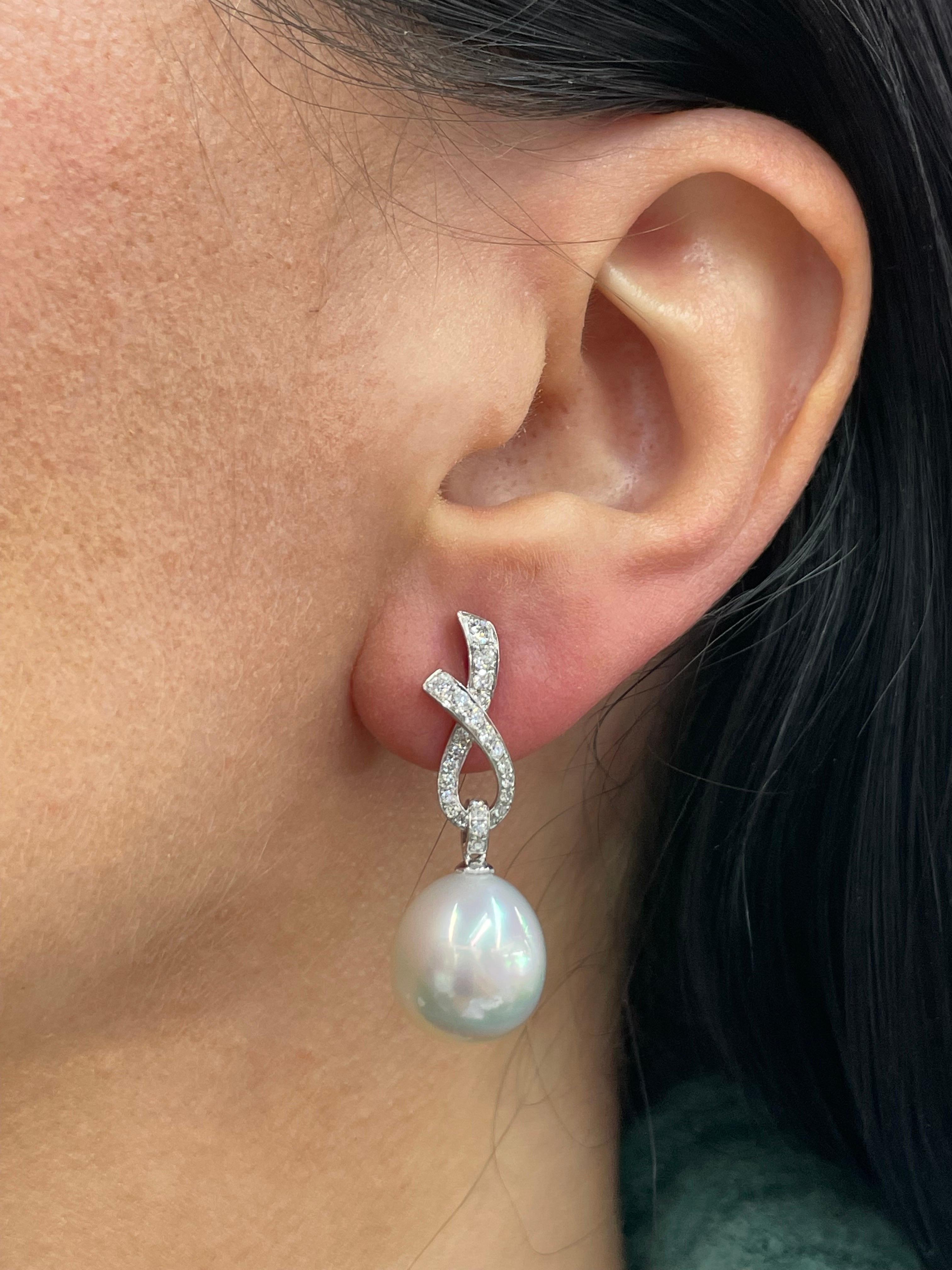 18 Karat White Gold drop earrings featuring a diamond ribbon motif containing 52 diamonds weighing 0.57 carats and two South Sea Pearls measuring 12-13 MM.
Color G-H
Clarity SI
Customize in different gold color & pearls. 