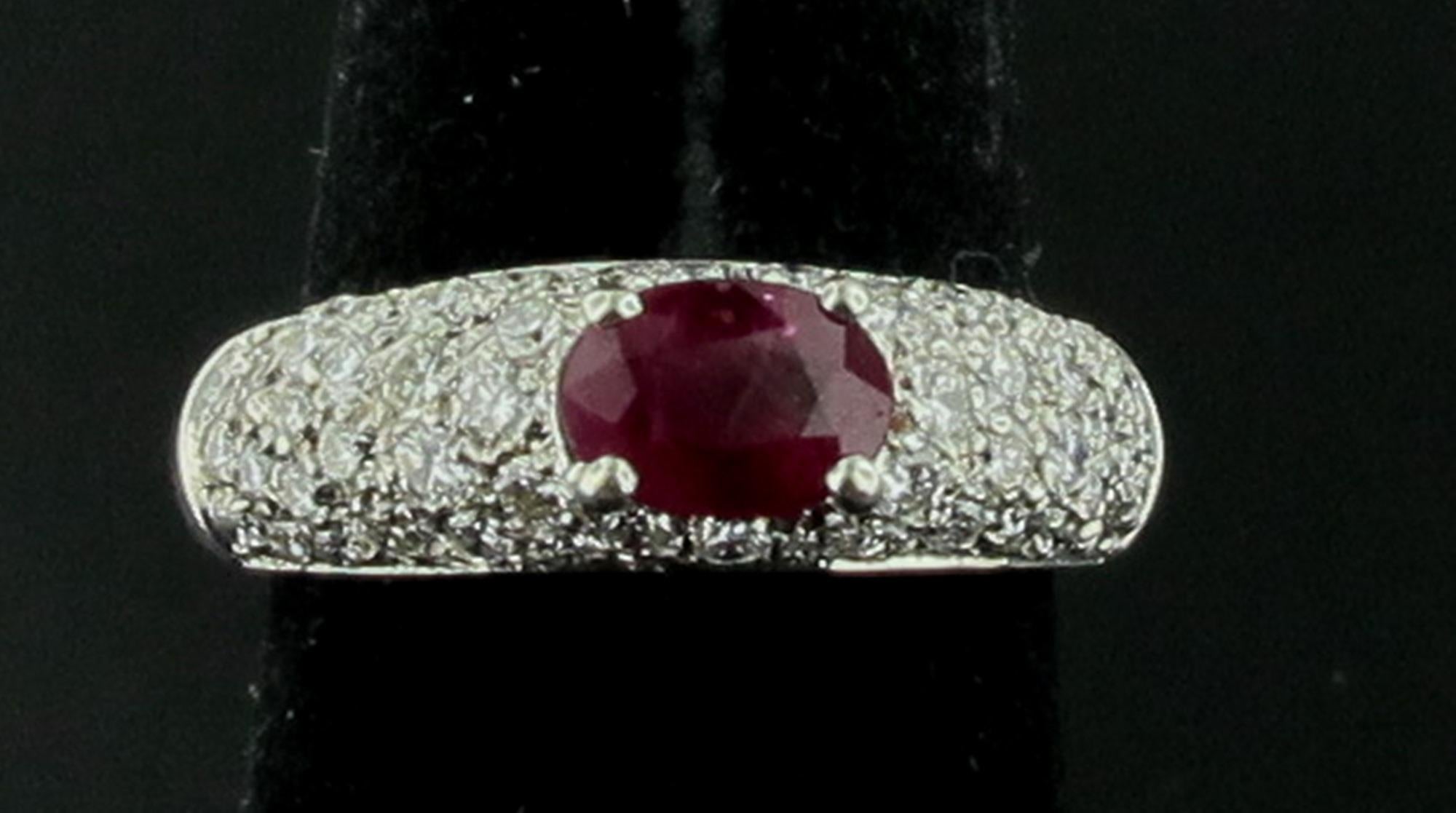 In 18 Karat Weißgold gefasst sind ein ovaler Rubin von 1,00 Karat und eingefasste Diamanten mit einem Gesamtgewicht von 1,00 Karat.  Farbe ist F, Klarheit ist VS.  Die Ringgröße ist 7.