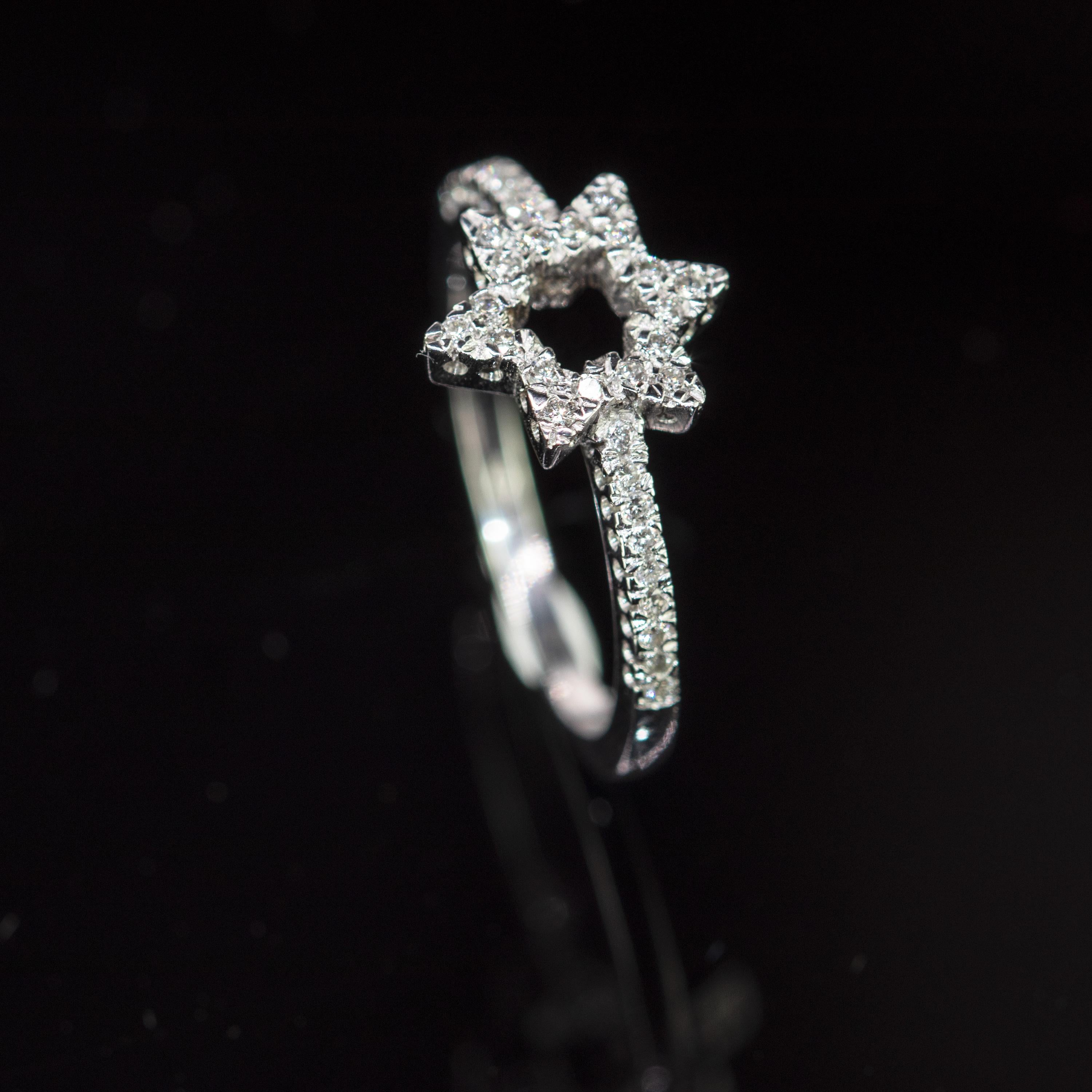 A delicate and sweet ring characterized by its diamonds that come together in the shape of a hexagonal star that sits on a band of diamonds in a 18k white gold setting.
 
This ring is inspired by the brilliance of its diamonds that from far away