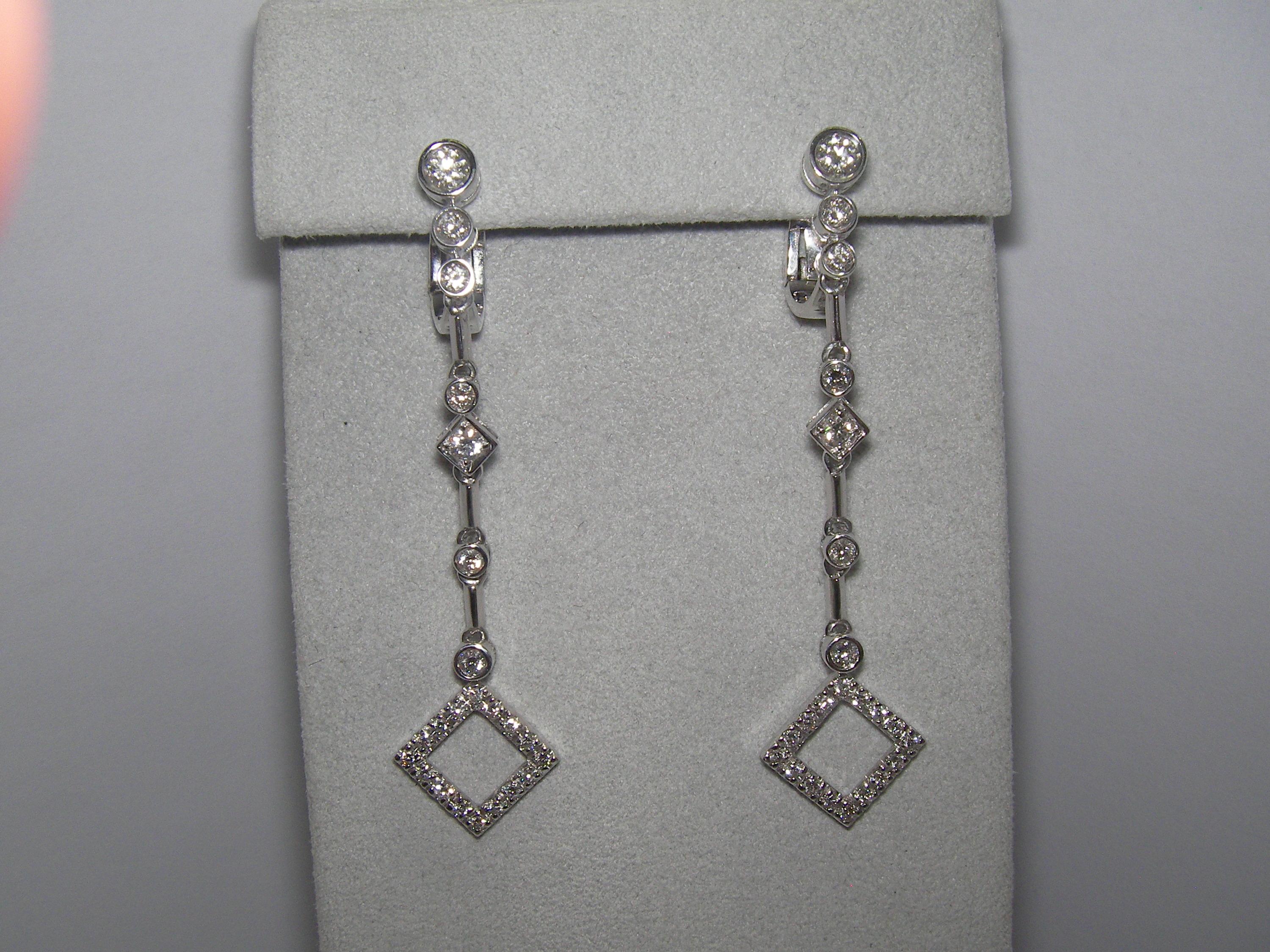 These 18 Karat White Gold Diamond Single Strand Dangle Earrings will be your go to set for date night or a beautiful evening out in the town. Three round diamonds are followed by a sequence of single stones just to finish in a rhomb shaped diamond