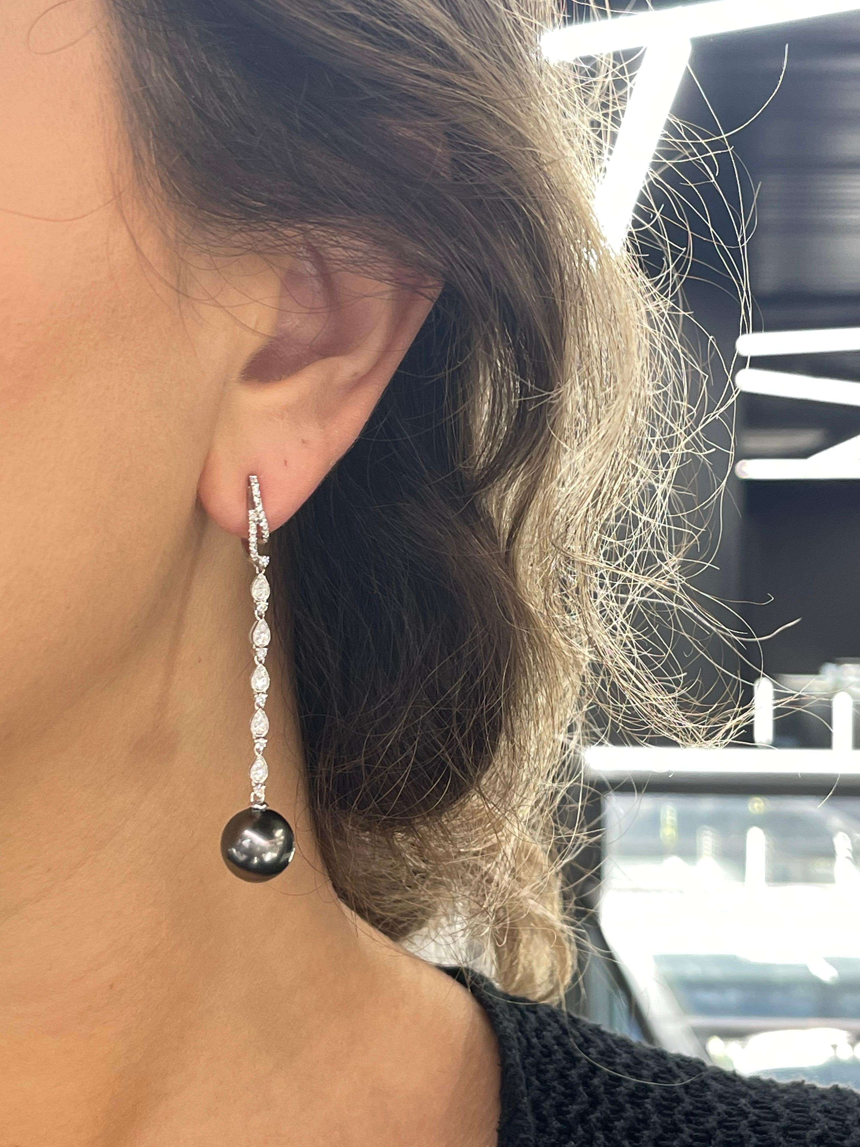 18 Karat white gold drop earrings featuring round brilliants weighing 0.58 carats and two Tahitian Pearls measuring 11-12 mm.
Color G-H
Clarity SI
Also Available in Yellow Gold. 