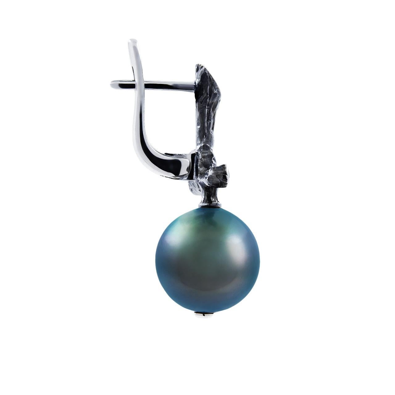 - 36 Round Diamonds - 0.23 ct, E-F/VS
- 11.5-12 mm Dark Tahitian pearls
- 18K White Gold 
- Weight: 9.64 g
This pair of earrings from the Eden collection features two Dark Tahitian pearls of 11.5-12 mm diameter. The design is complete with 36