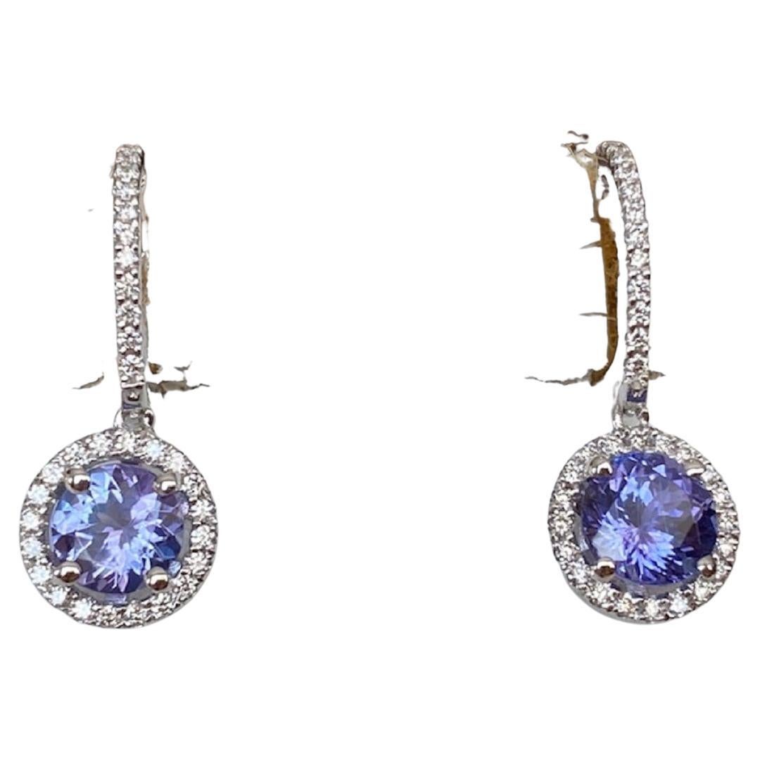 On offer, white gold stud earrings set with two round faceted tanzanite stones of AA quality, approx. 1.80 ct in total combined. The stones are surrounded by an entourage of 68 brilliant cut diamonds of approx. 0.68 ct in total and of quality