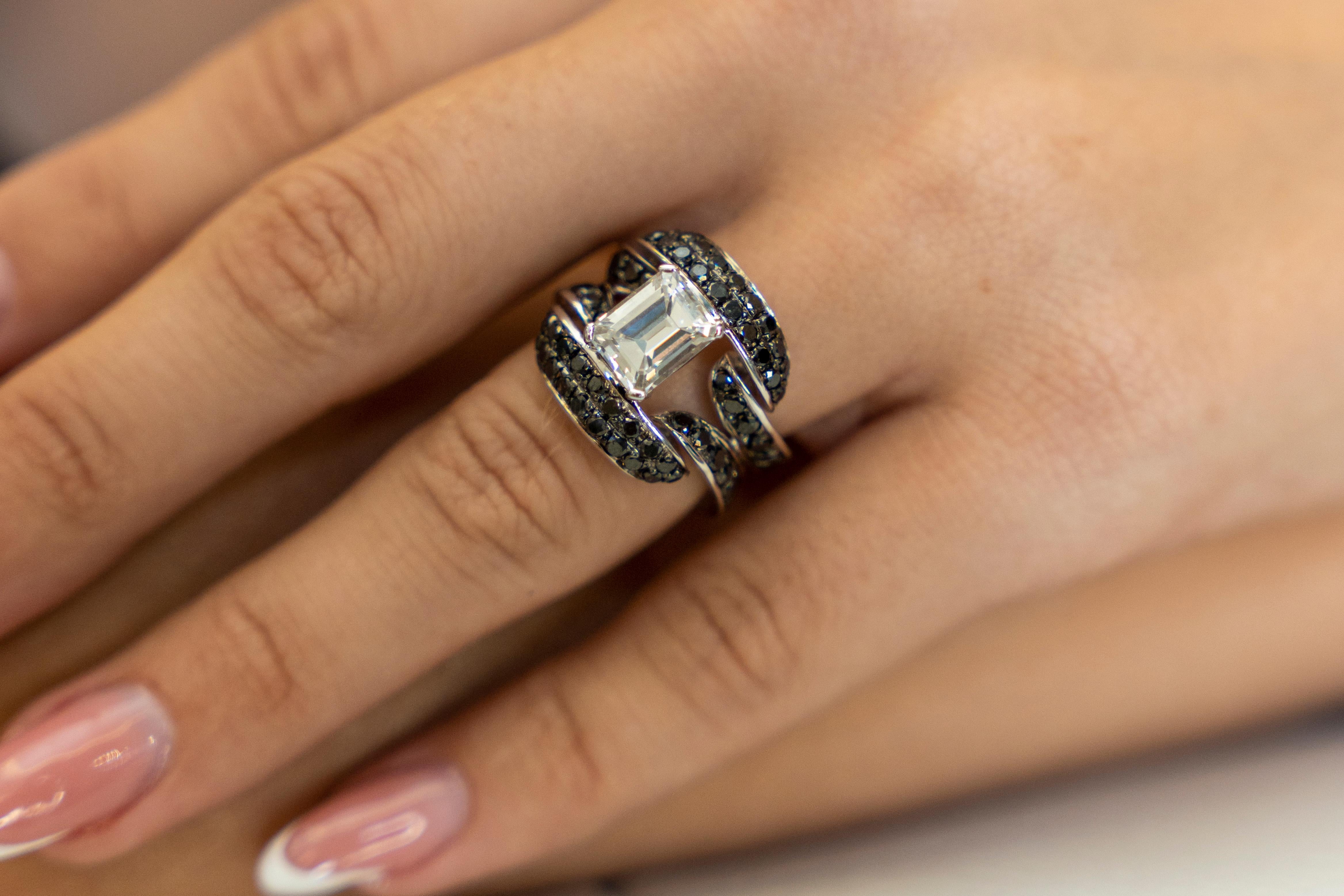 18K white gold cocktail ring is from Timeless Collection. This elegant piece of jewellery is made of central emerald cut colorless diamond in G color and VS2 clarity in total of 1.98 Carat decorated by black diamonds in total of 2.14 Carat. Total