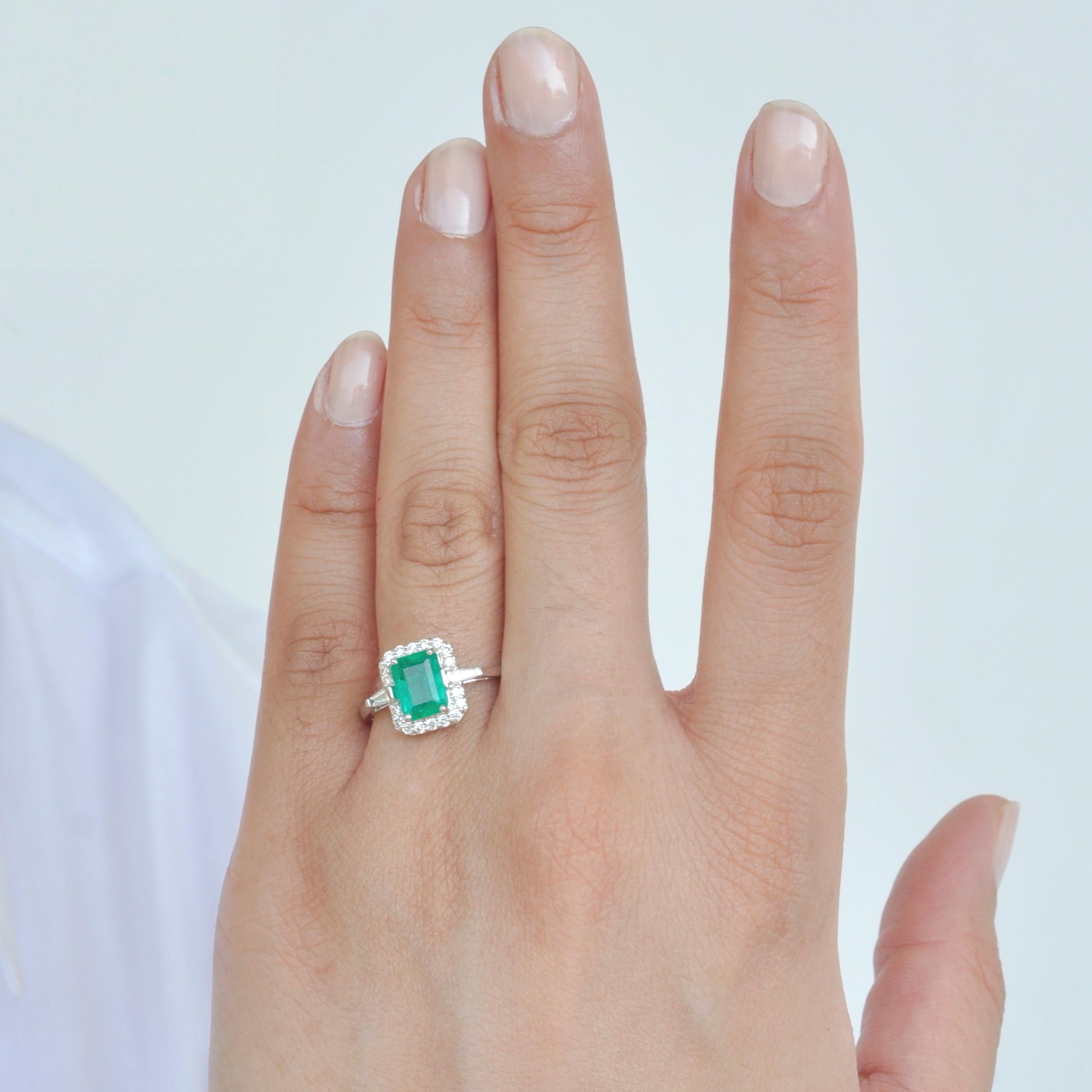 18 karat white gold emerald cut 8 x 6 mm colombian emerald diamond contemporary ring suitable for bridal and engagement occasions. 
This emerald diamond ring personifies simplicity and elegance. Encircling the Colombian emerald are brilliant cut