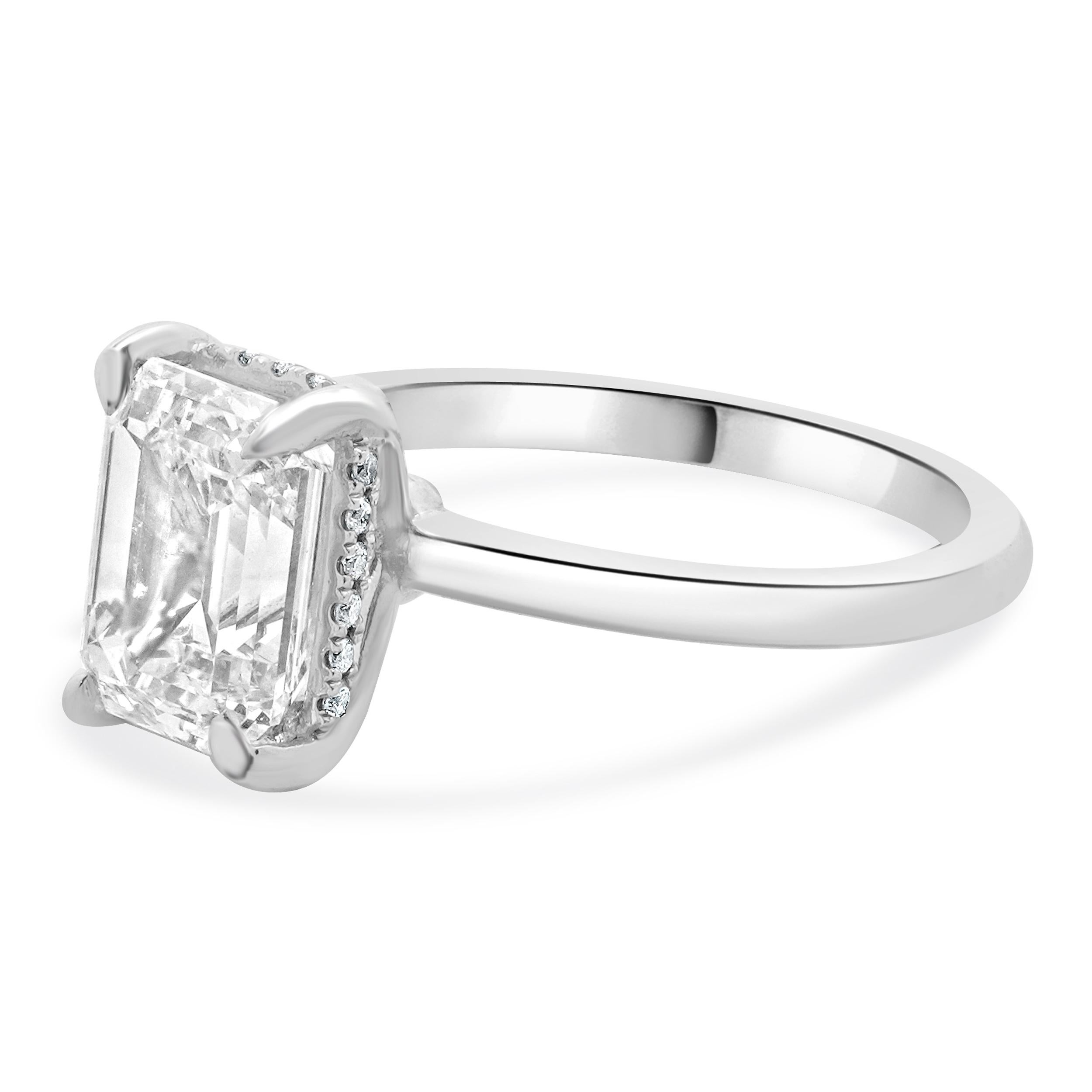 Designer: custom
Material: 18K white gold
Diamond:  1 emerald cut = 2.05ct
Color: E
Clarity: VS1
GIA: 16843147
Diamond: 20 round brilliant cut = 0.10cttw
Color: G
Clarity: VS1-2
Dimensions: ring top measures 8.5mm wide
Ring Size: 6.5 (complimentary