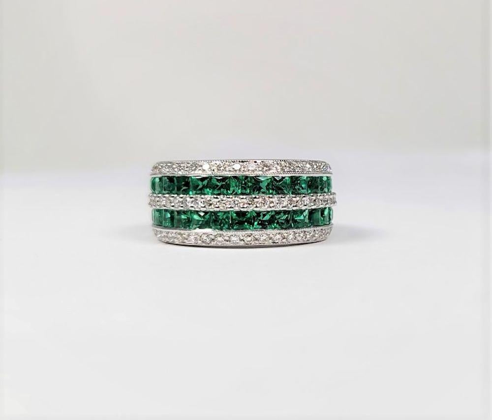 This stunning 18 karat white gold ring supports two rows of beautifully matched emeralds, weighing a total of 1.70 carats and three rows of diamonds, 0.65 cts  VS in clarity and G - H in color.