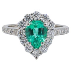 Anillo de cóctel de oro blanco de 18 quilates con halo de esmeralda y diamante natural