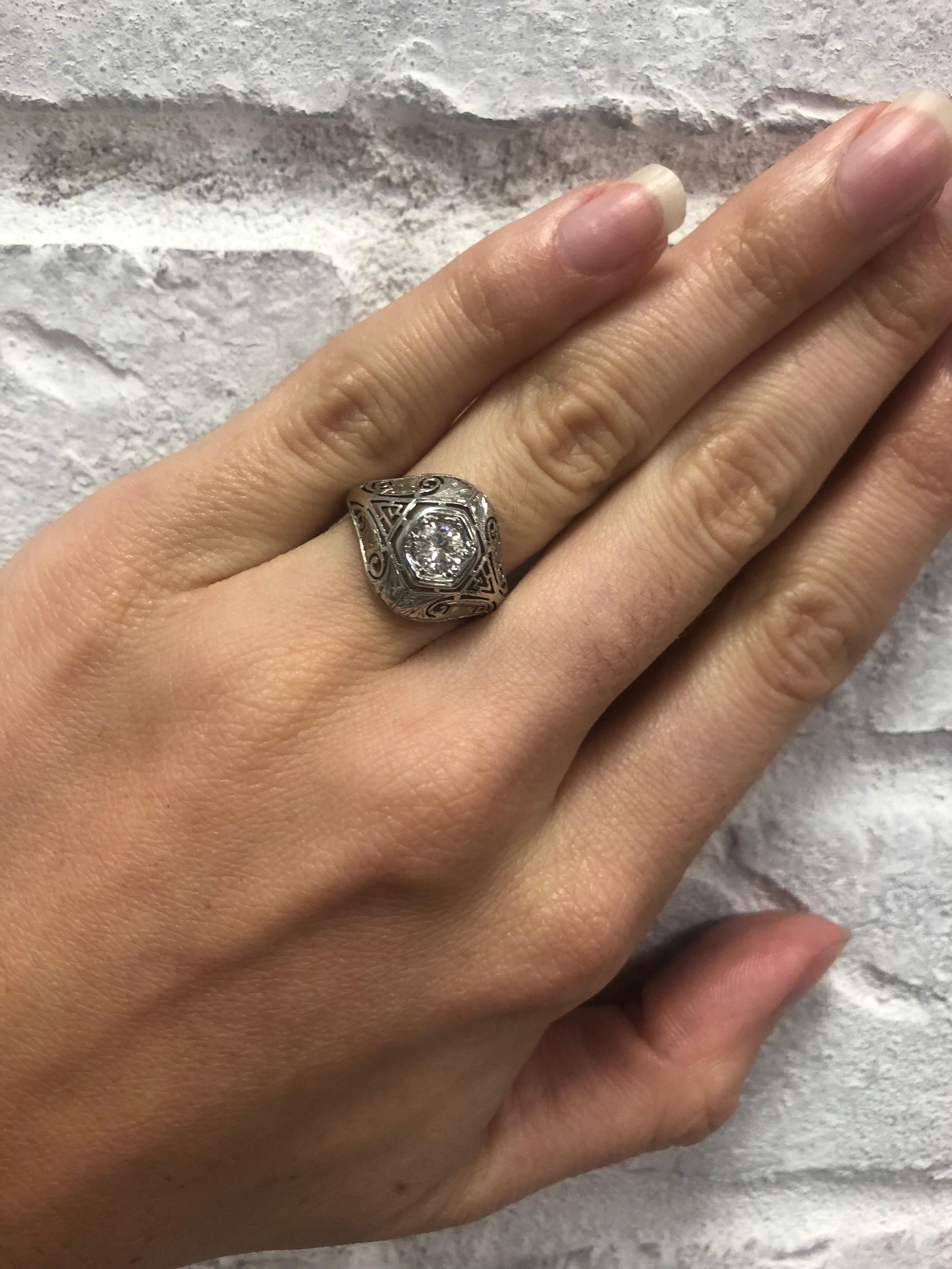 Vintage 18 karat white gold filigree antique style ring with a round brilliant cut diamond that is approximately .30 carat total weight. The diamond features a H in color and SI1 in clarity. Size 4 3/4 can be sized up and down complimentary with